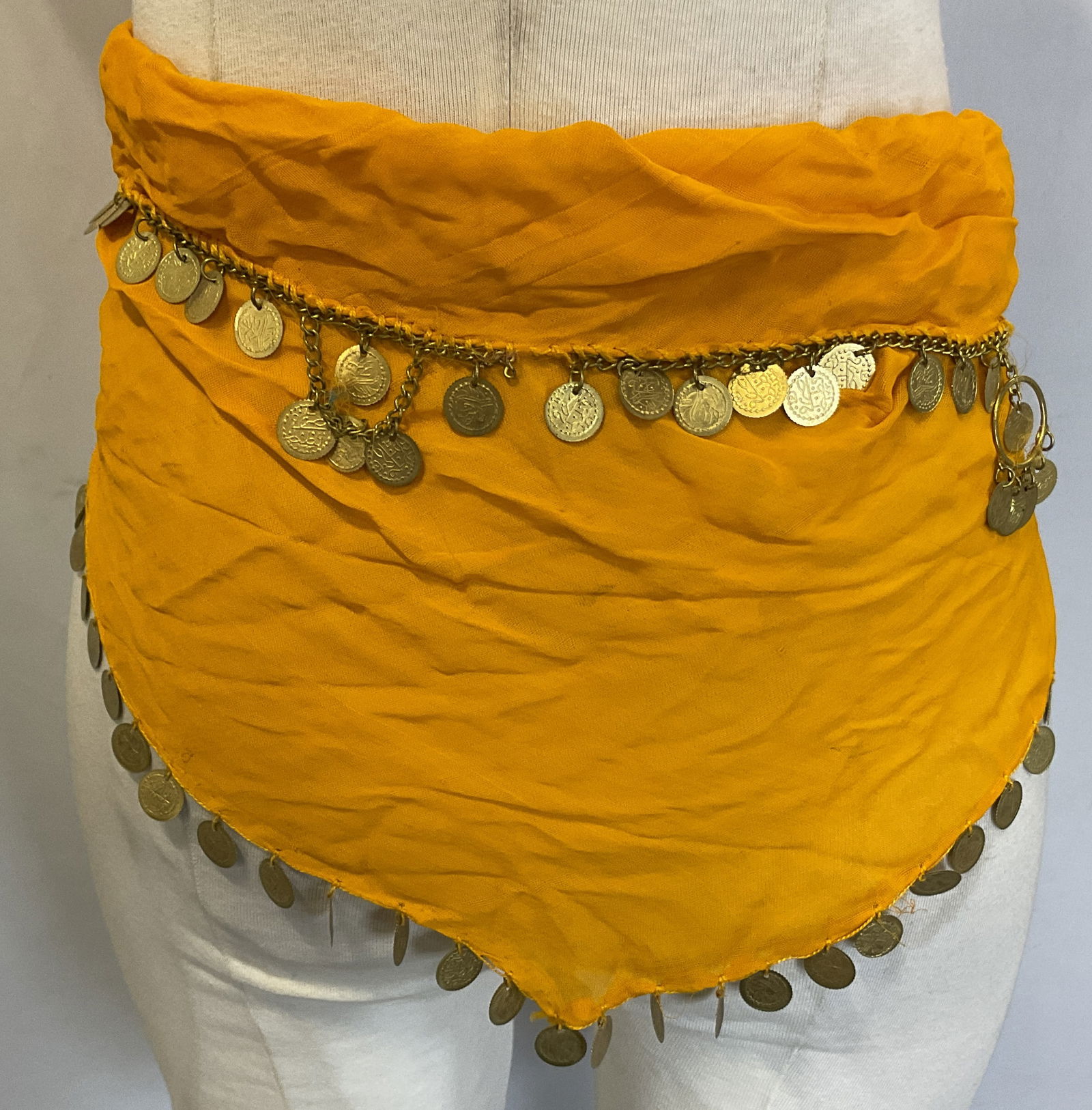 Vtg Belly Dance Embellished Hip Scarf: Vintage belly dance embellished hip scarf. Orange sheer scarf, feels like silk. Embellished with gold toned coins that have embossed patterns on them. Often worn on belly dancers as costumes for