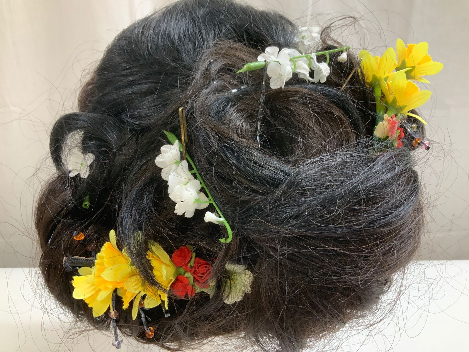 Harlem 125th Lovely Collect Human Hair Costume Wig: 100% human hair. NYC Opera Madama Butterfly. Costume wig features white, yellow, pink & red floral accents. Hair clip accent at front. Signed & marked. Reads, HARLEM 125TH LOVELY COLLECTION. NEW JIGU.