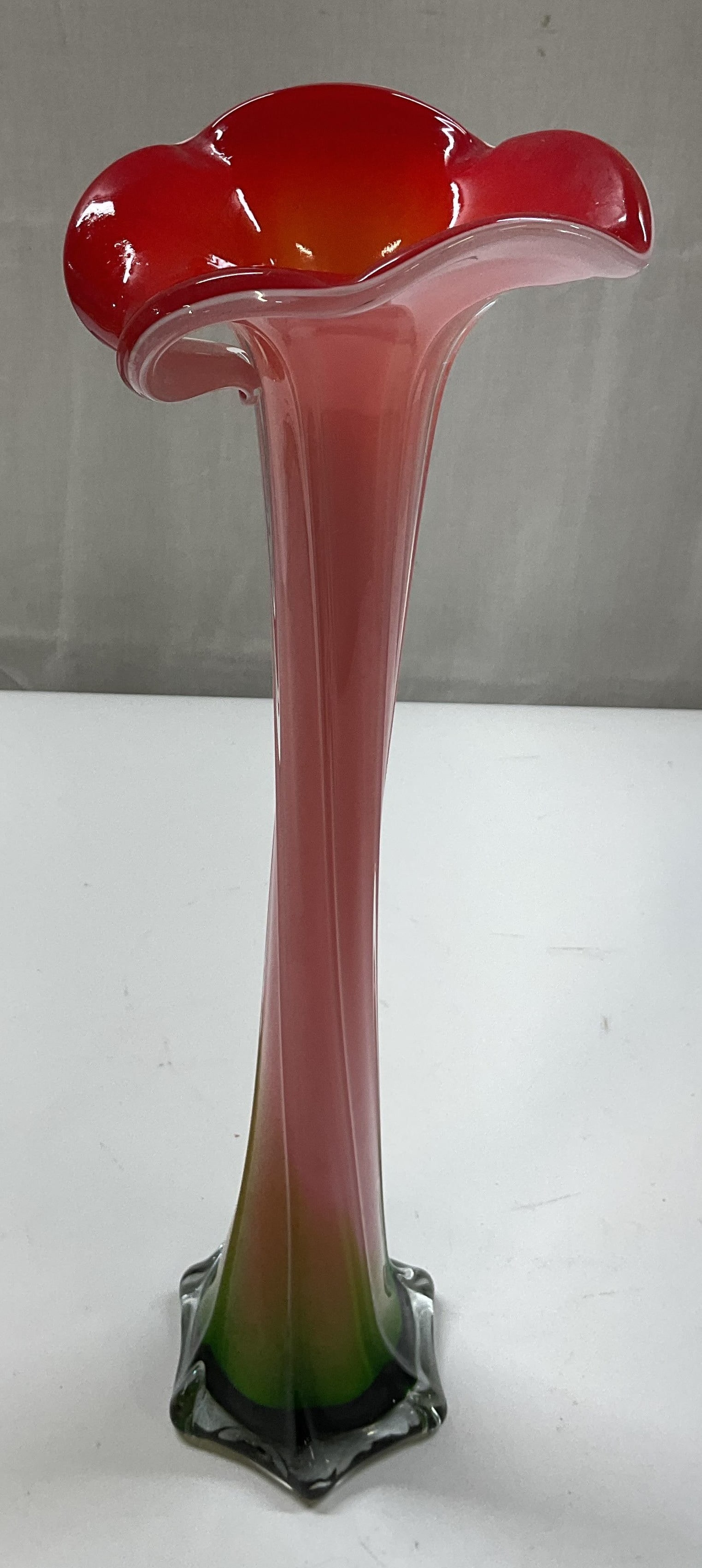 Hand Blown Art Glass Ruffled Bud Vase: Hand blown art glass ruffled bud vase. Ruffled scalloped edge. Vertical lines swirl upwards. Pink, red, and green. Scalloped round base. Measures ht approx 15 inches base diam approx 4 inches. Surface