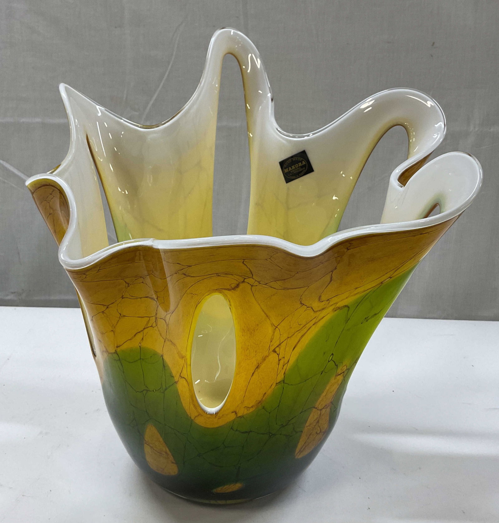 Hand Made Makora Art Glass Vase Poland: Hand made Makora art glass vase. Sticker adhered to surface, reads Hand Made Makora Krosno Made In Poland. Handkerchief ruffled edge design. Combination of green and yellow with abstract pattern. Cut