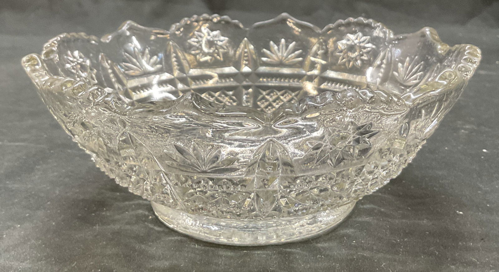 Vintage Cut Glass Decorative Bowl: Vintage cut glass decorative bowl. Scalloped and sawtooth edge. Cut designs featuring fan, starburst, and diamond patterns. Detailed features and textures. Measures ht approx 3 inches diam approx 7 in