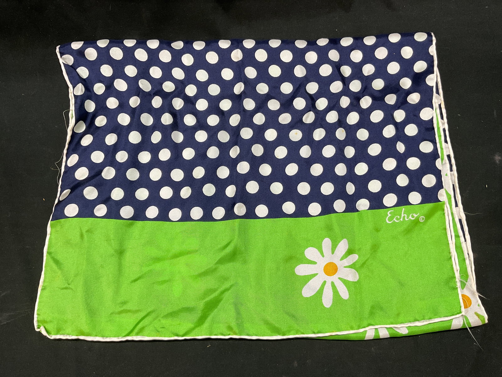 Echo Polka Dot Floral Silk Scarf Japan: Echo polka dot floral silk scarf. Made in Japan. Silk material. Signed. Polka dot pattern and floral motifs. Green, blue, white, yellow. Measures approx 14 x 43 inches. Some blemishes and pull to stit