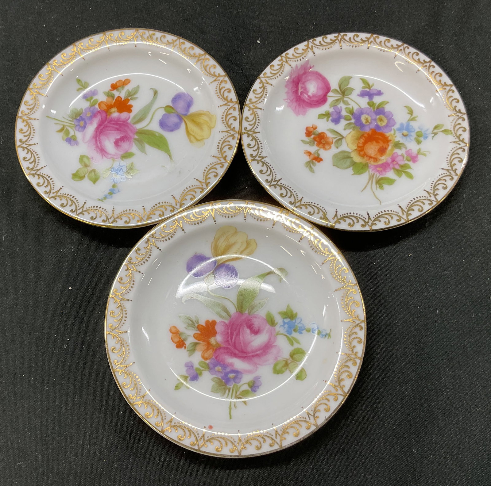 Lot 3 Rosenthal Porcelain Trinket Dish Germany: Lot of 3 Rosenthal porcelain trinket dishes. Marked on underside, reads Rosenthal Selb Bavaria. Round dishes. Ornate gilt scroll motif border. Floral motifs in center in varying colors. Gilt rim. Meas
