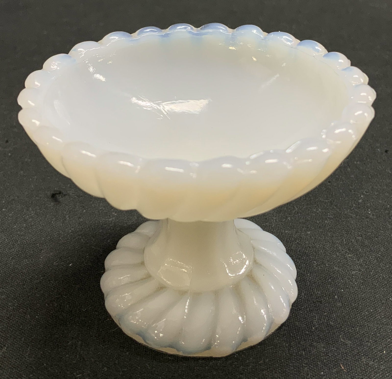 Antique Milk Glass Scalloped Compote: Antique, possible vintage. Milk glass compote features a pedestal base & scalloped edge. Hue of blue. Possible wafer tray. No visible signature or markings. Surface wear consistent to age, use & expos