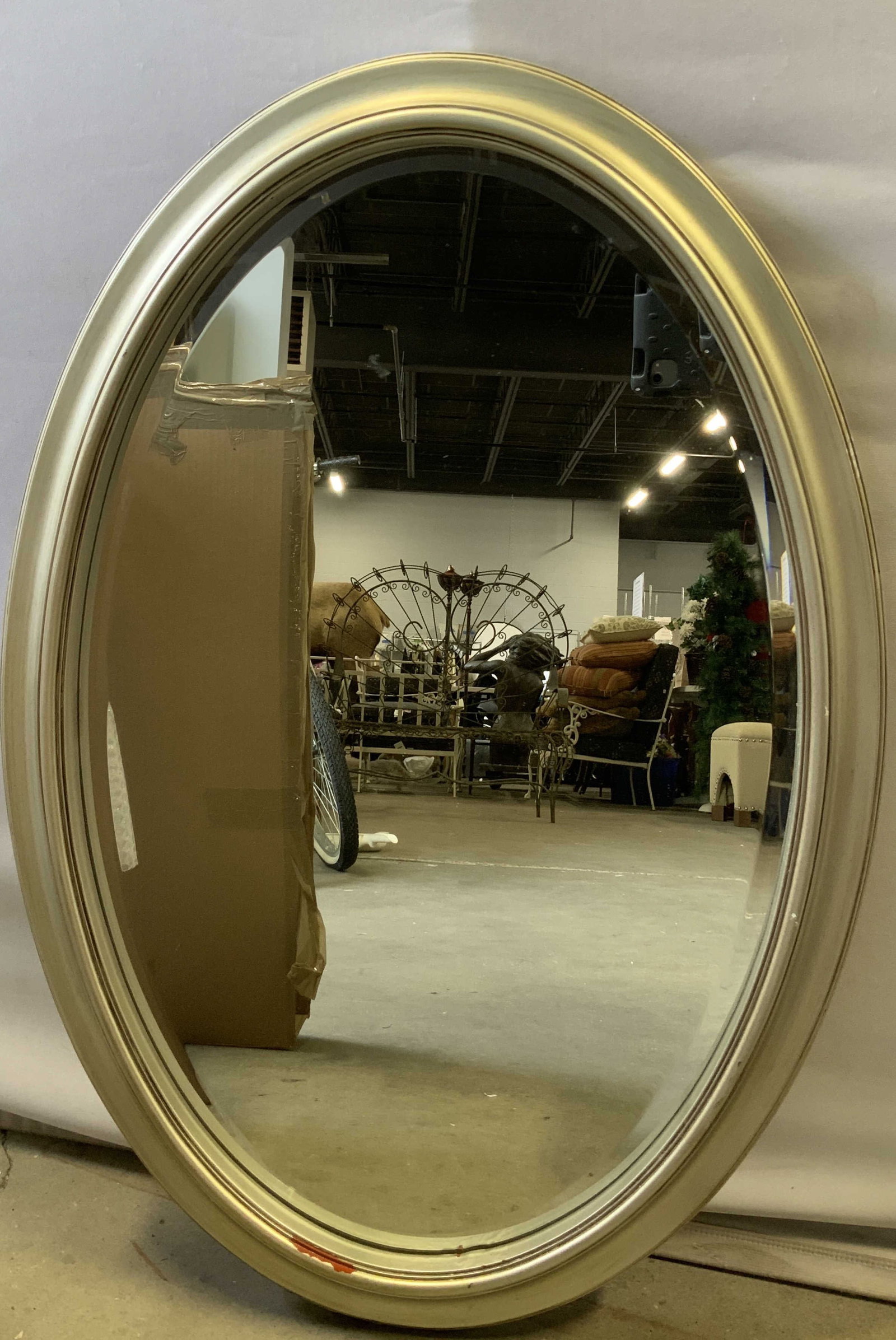 Vtg Silver Toned Wooden Oval Mirror: Vintage wooden wall mirror is silver toned. Oval shaped. Hooks on back. Sold as is. No visible signature or markings. Surface wear consistent to age, use & exposure. Chipping. Measurements: width 21.6