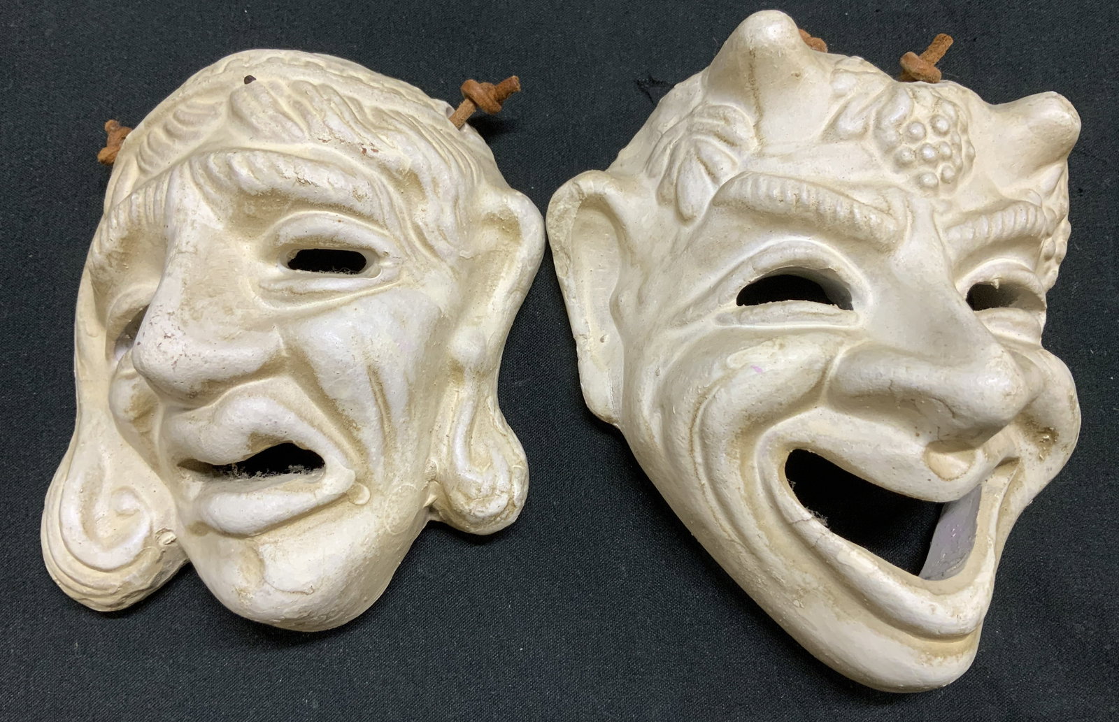 Lot 2 Vtg Drama Theater Ceramic Masks GREECE: Lot includes, 2 drama theater style ceramic wall masks featuring a sorrow & joyful face. White toned. Signed & marked. Reads, CERAMICS MADE IN GREECE. Surface wear consistent to age, use & exposure. M