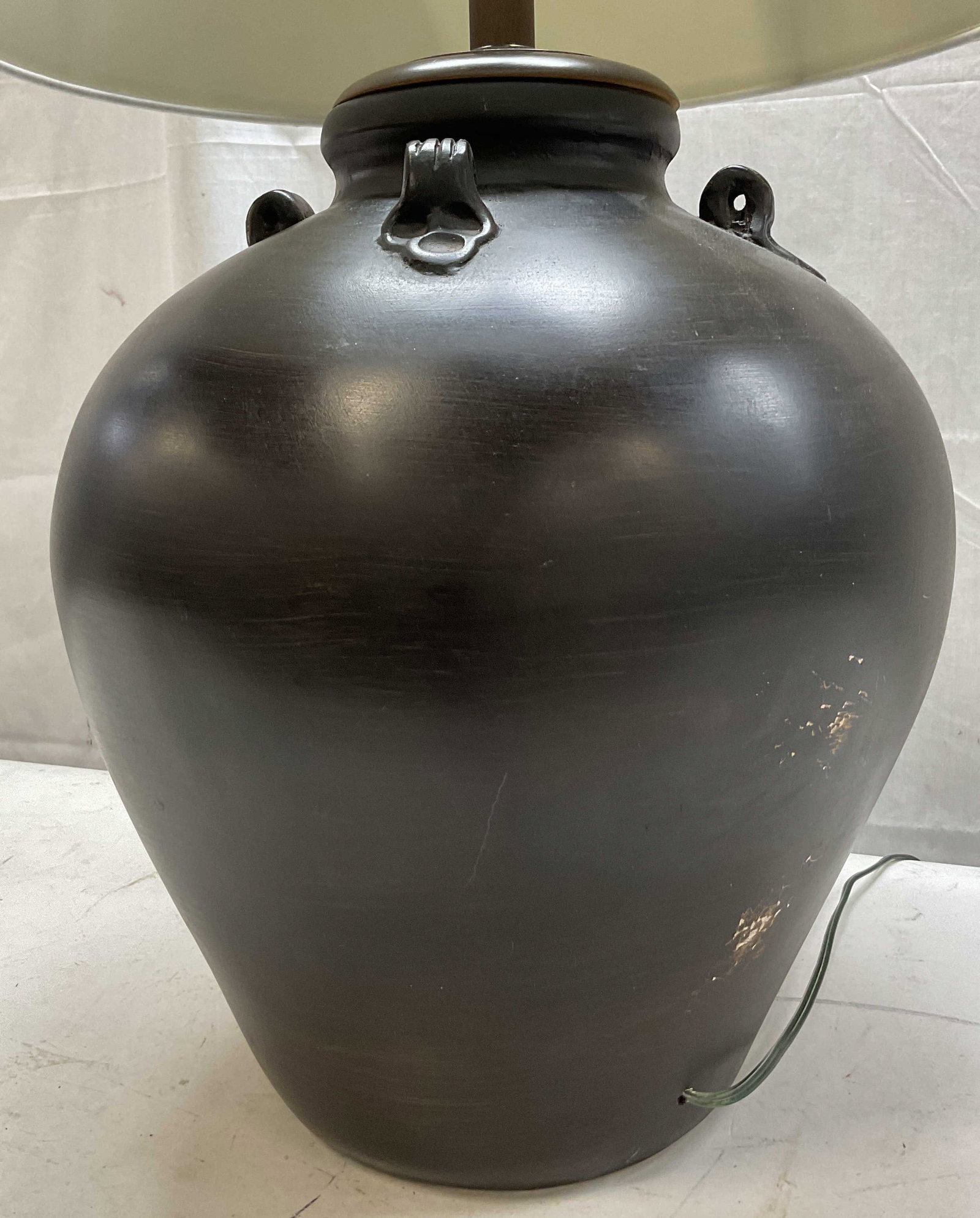 Vintage Black Ceramic Table Lamp W Shade: Vintage black ceramic table lamp. Comes with white fabric shade. Round bulbous body. Applied embossed scroll motifs. Hand painted black and brown mixture. Ball shaped finial. Measures ht approx 29 inc