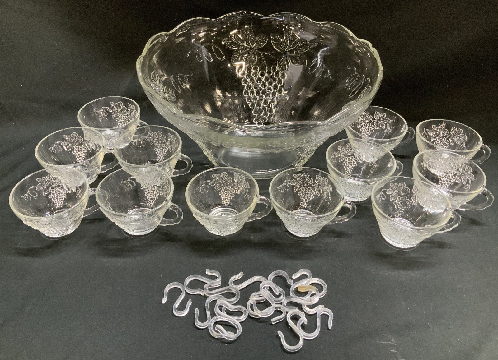 Vtg Anchor Hocking 28 Pc Party Starter Punch Set: Lot includes, vintage Anchor Hocking 28 piece party start punch bowl set. 1 punch bowl, 12 cups & 15 hangers. Comes with its original box. Pieces feature embossed grapevine patterns. Sold as is. Surfa