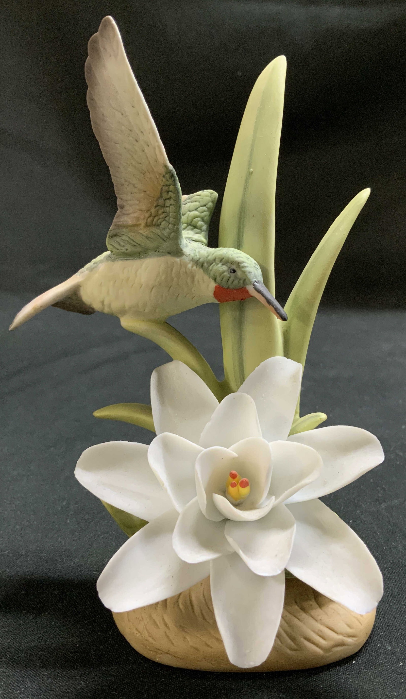 1983 Lefton China Hummingbird Porc Figurine: Lefton China porcelain figurine decorating a hummingbird perched on a flower. Shades of green, white, yellow, orange & brown. Signed & marked on underside. Reads, LEFTON CHINA HAND PAINTED. HUMMING BI