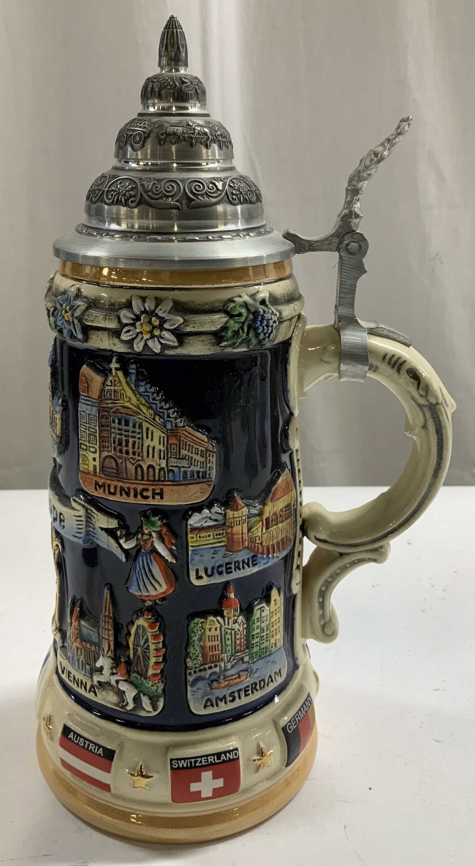 Handmade Authentic Bohemian Beer Stein: Handmade ceramic beer stein features raised relief depictions of landmarks from European cities including Munich, Lucerne, Vienna, Amsterdam & more. Silver toned lid. Signed & marked on underside. Rea