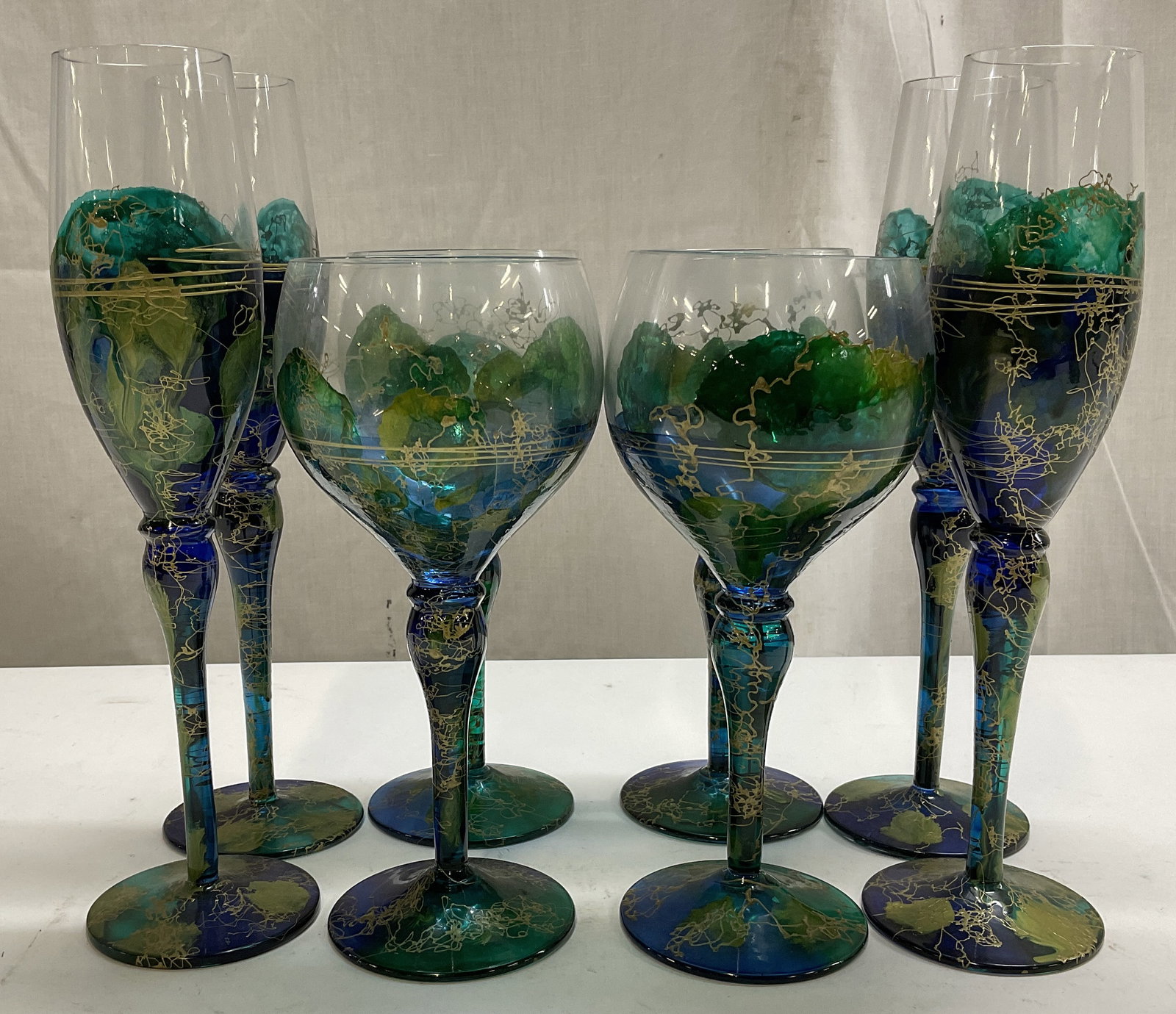 Lt 8 Hand-Painted Lagoon Style Glasses: Lot of 8 Hand-Painted Lagoon Style Glasses. 4 Wine Glasses, 4 Champagne Flutes. Lagoon Style Design with Blue, Teal, Green. Gold Toned Accents. Romanian Style. Flutes measure app 9.5in H x 1.5in diame