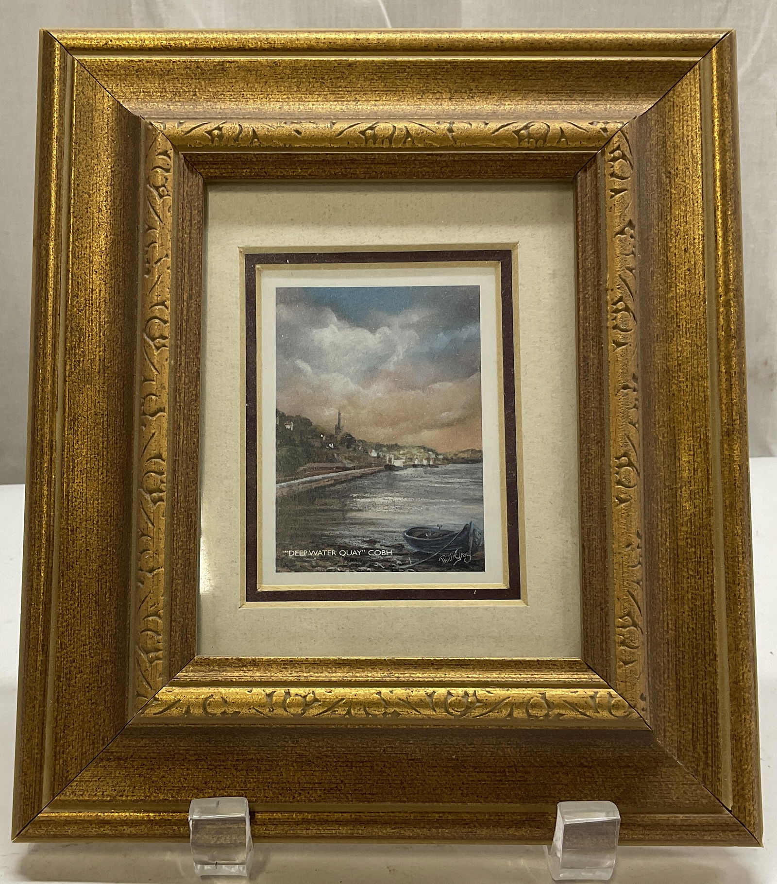 Philip Gray Deep Water Quay COBH Framed Print: Artist Philip Grays Deep Water Quay COBH Framed Print. Features a coastal scene. Gold Toned Frame. Measures app 8in H x 7in L. Condition consistent with exposure. Artist Philip Gray, Deep Water Quay C