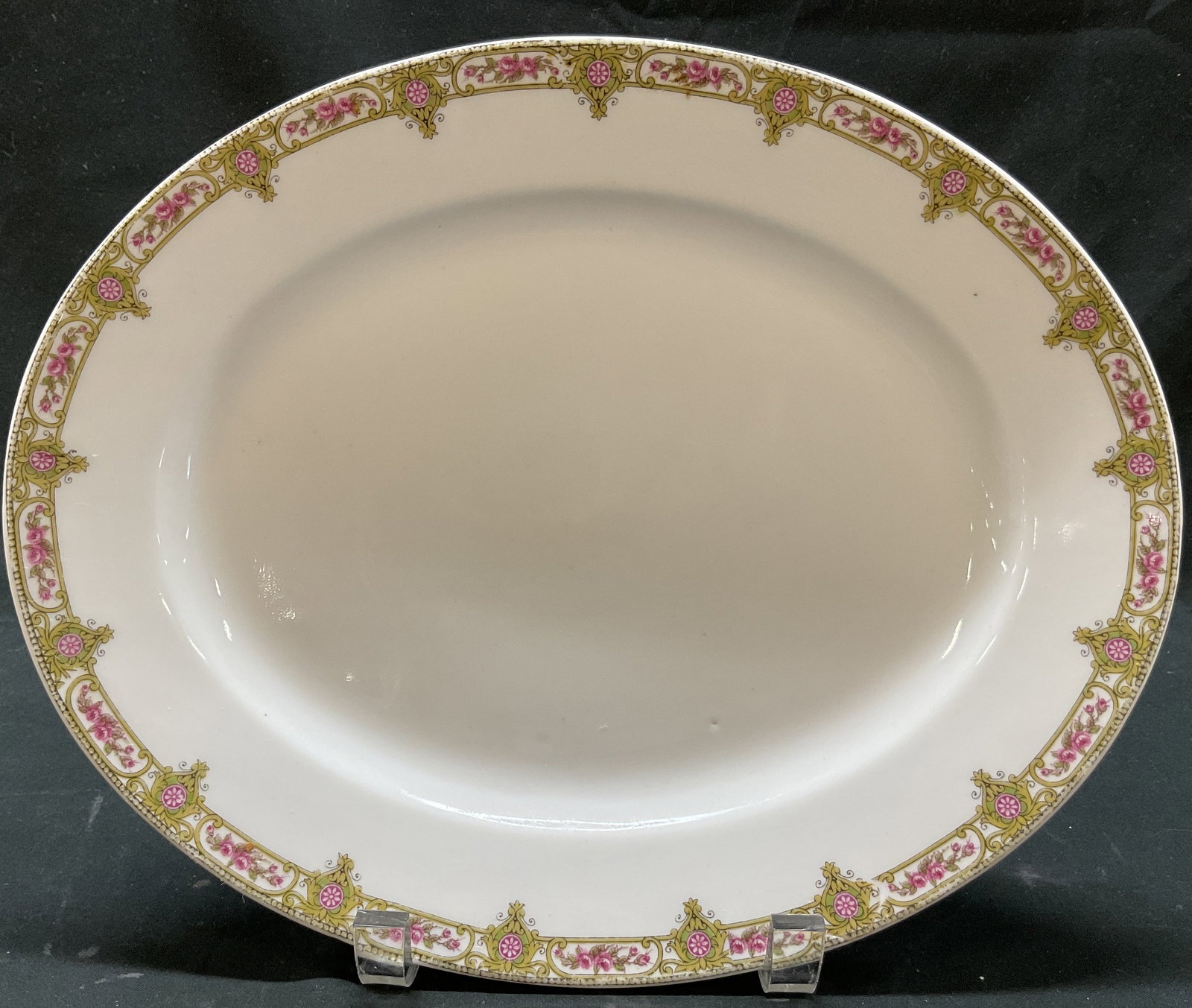 1917 Limoges Porcelain Oval Floral Plate France: Limoges porcelain oval floral plate. Marked on underside, reads Limoges France 1917. Oval shape. Ornate floral and scroll motif border in varying colors. Measures approx 9 x 11 inches. Some scratching