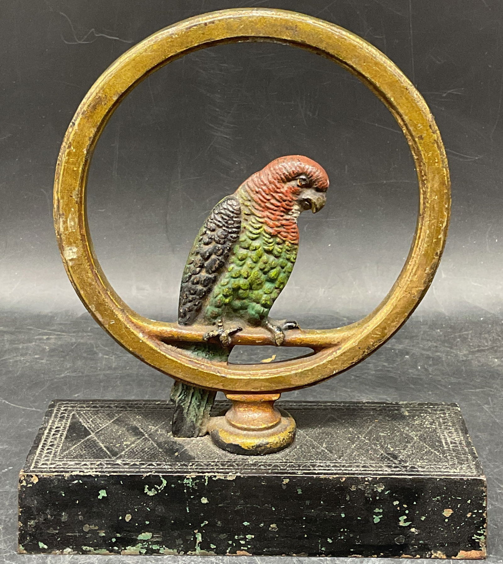 Antique Art Deco Cast Iron Parrot Doorstop: Antique art deco cast iron doorstop. Parrot perched in ring. Hand painted and gilt decoration. Measures approx. 7 x 2.5 x 8 inches. Piece has significant weight. Wear including scratching and loss to