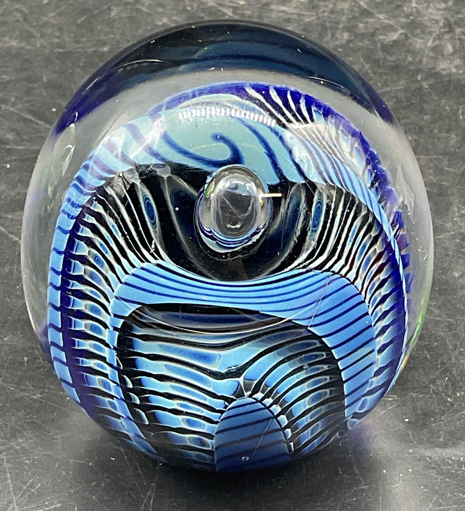 Robert Eickholt Blue Ribbon Art Glass Paperweight: Signed Robert Eickholt 1989 hand blown art glass paperweight. Blue ribbon design with controlled bubble. Measures approx. 2.5 x 2.75 inches. Some scratching. Robert Eickholt paperweight, art glass pap