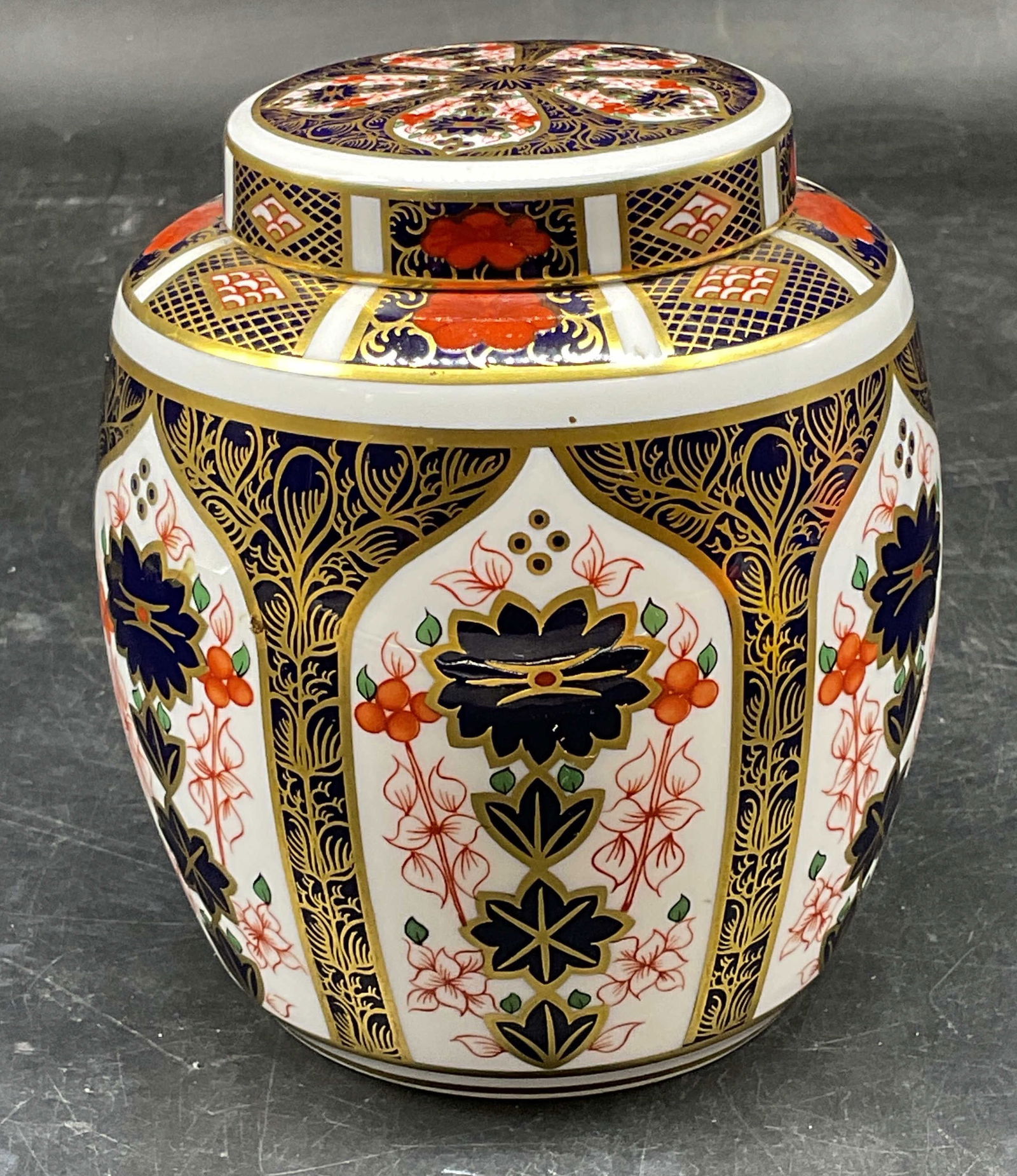 Royal Crown Derby Imari China Ginger Jar England: Signed Royal Crown Derby bone china ginger jar. Imari pattern. Cobalt blue and red with gilt decoration. Hand painted. Made in England. Measures approx. 3.75 x 4.5 inches. Some wear including scratchi