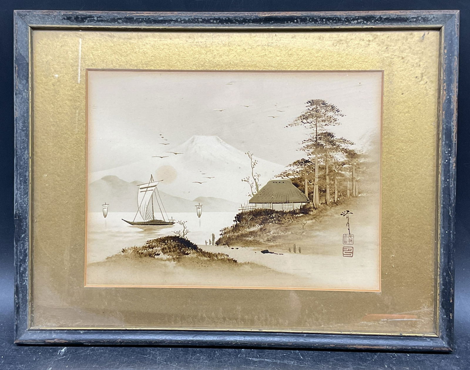 Signed Japanese Landscape Gilt Watercolor: Framed and matted watercolor and gilt painting. Signed at lower right. Scenic landscape with boat and building. Black wood frame. Not examined out of frame. Frame measures approx. 9.75 x 12.75 inches.
