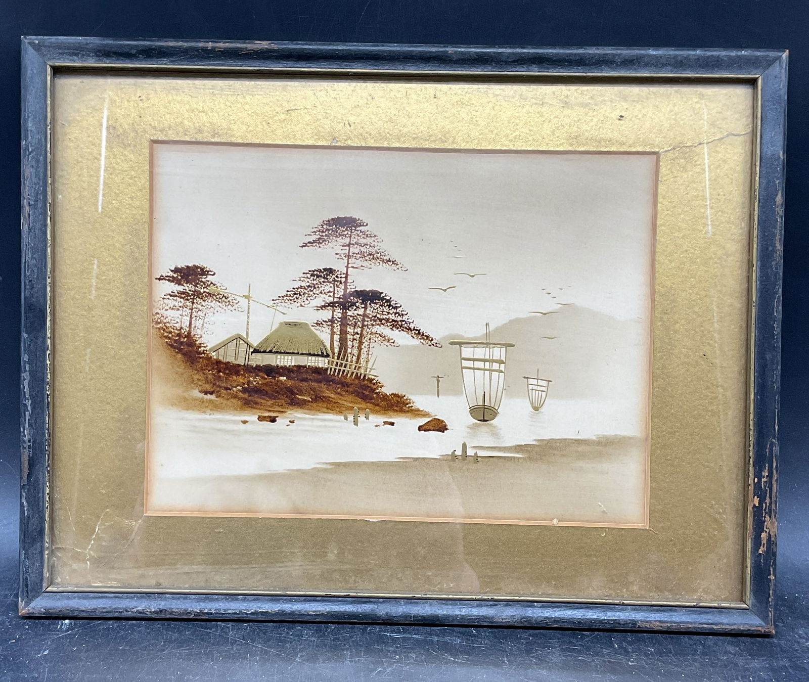 Framed Japanese Scenic Landscape Gilt Watercolor: Framed and matted watercolor and gilt painting. Scenic Japanese landscape with boats and building. Black wood frame. Not examined out of frame. Frame measures approx. 9.75 x 12.75 inches. Wear includi