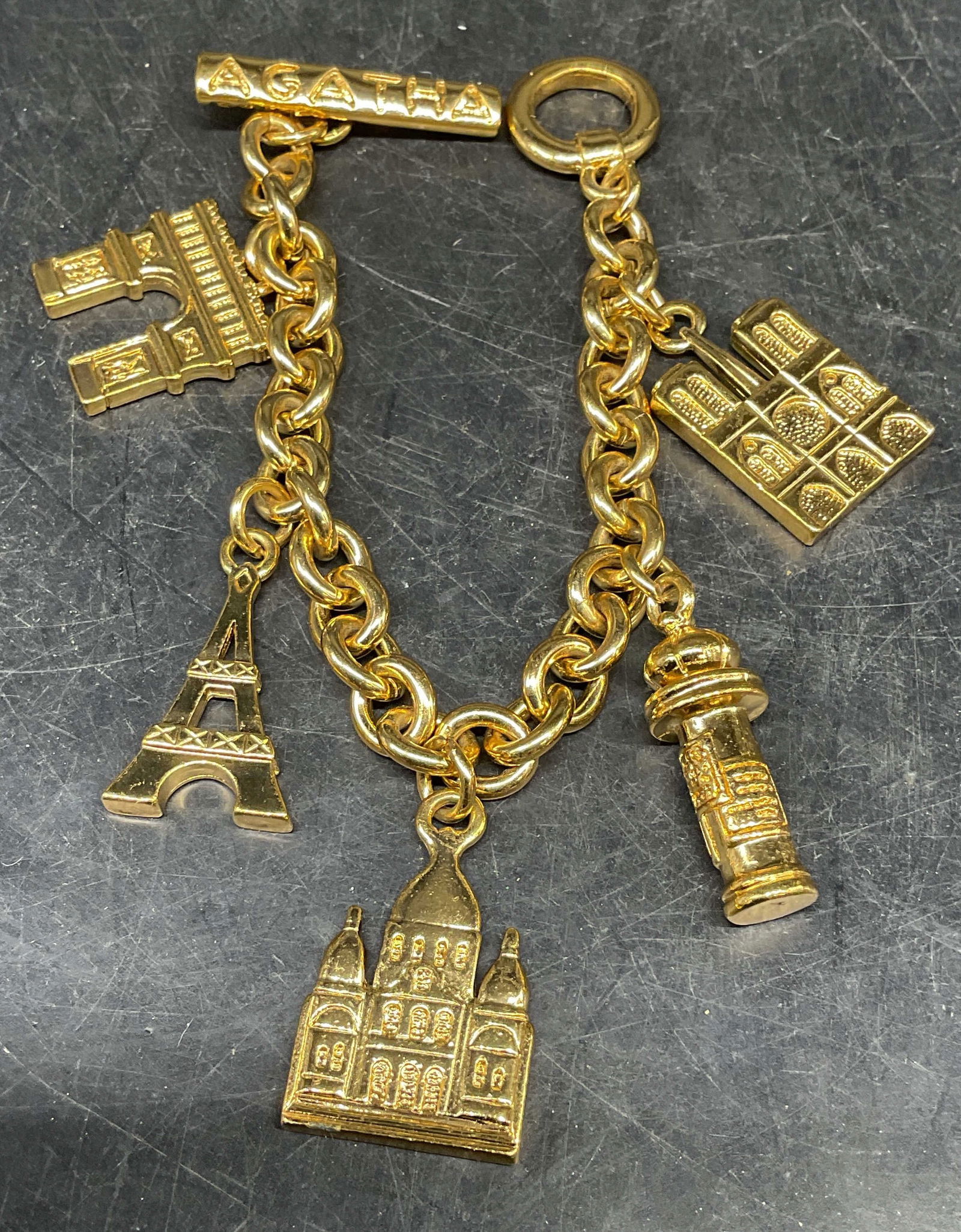 Vintage Agatha Paris Gold Tn Charm Bracelet: Vintage signed Agatha Paris gold tone charm bracelet with Paris landmarks. Measures approx. 8 inches long. Some scratching. Jewelry, estate jewelry, costume jewelry, cocktail jewelry, fashion jewelry,