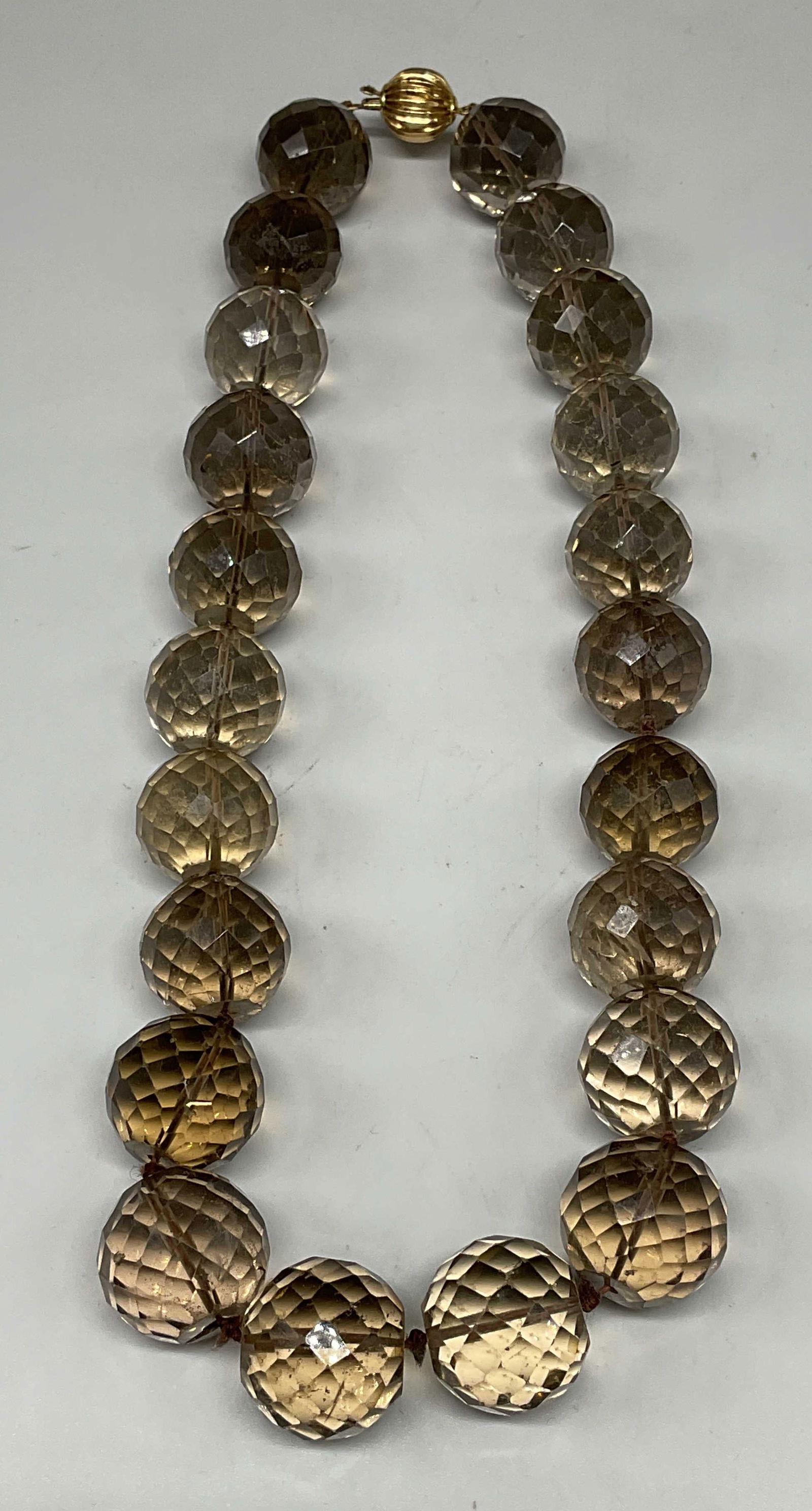 Vtg 14k Gold Semiprecious Beaded Necklace: Vintage Smokey semiprecious faceted gemstone beaded necklace with 14k gold clasp. Marked 14k. Additional mark illegible. Drop length approx 7 inches. Total weight 151.9 grams. Some scratching. Jewelry