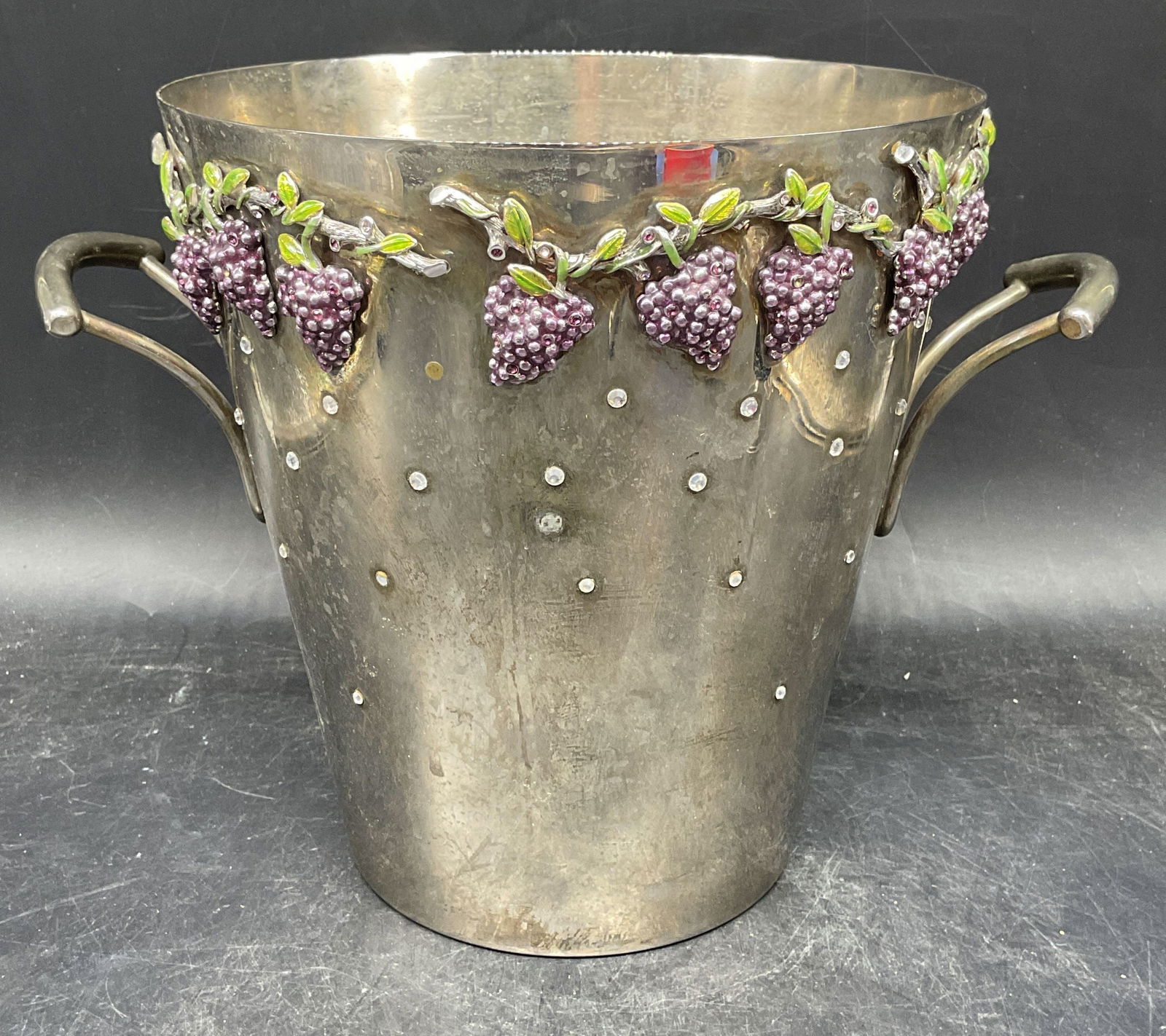 St John Silver Pl Crystal Grape Champagne Bucket: Vintage signed St John silver plate champagne bucket with enamel and crystal decoration. Grape motif. Measures approx. 7.75 x 8.25 inches. Wear inc patina, scratching, loss to crystals and