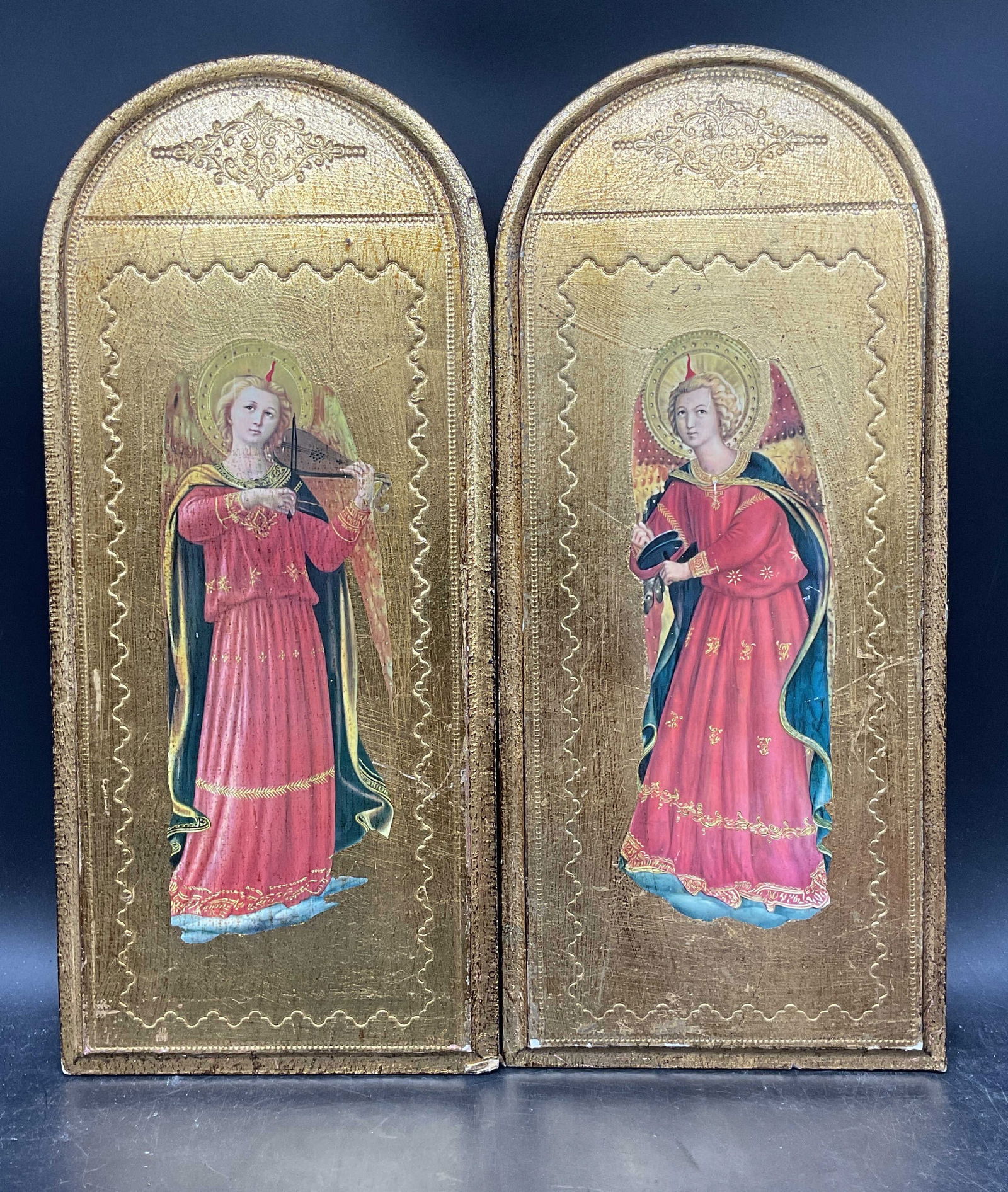 Pair Florentine Fra Angelico Musician Angels: Pair of vintage Florentine gilt wood diptych panels. Lithographs after Fra Angelico, Musician Angels. Panels measures approx. 16 x 7 inches each. Wear including scratching and loss to gilt.