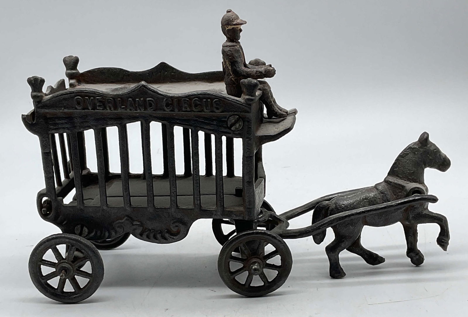 Vintage Iron Art Overland Circus Wagon: Vintage signed Iron Art cast iron JM 109 Overland Circus horse drawn wagon and rider toy. Measures approx. 10.5 x 3 x 7.25 inches. Wear including patina, scratching, loss to paint. Property of Manhatt