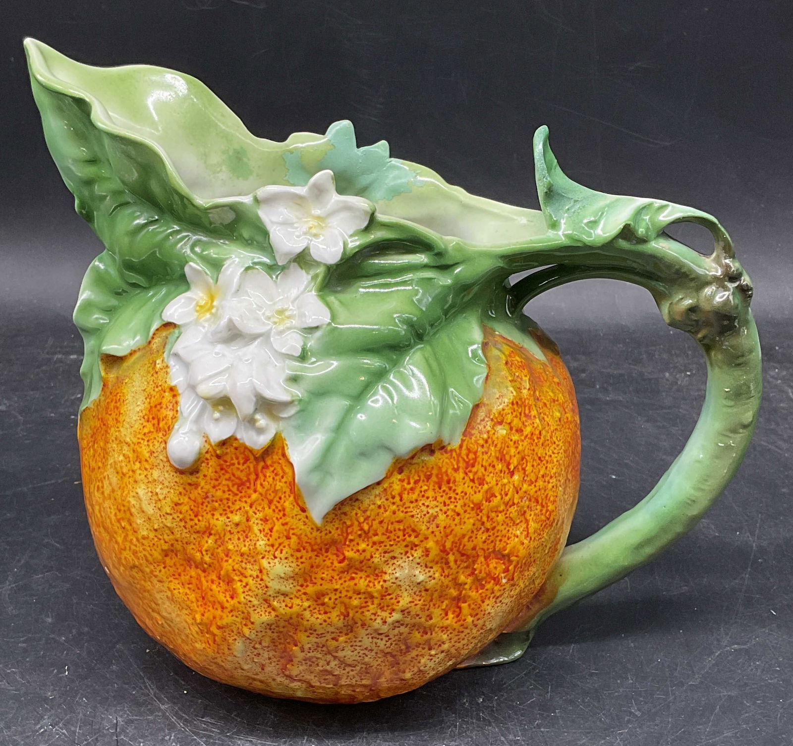 Antq Royal Bayreuth Porc Orange Pitcher Germany: Antique signed Royal Bayreuth porcelain orange motif pitcher. Hand painted orange and green. Textured surface. Blue Backstamp. Made in Germany. Measures approx. 8.5 x 5.25 x 7.25 inches. Some wear inc