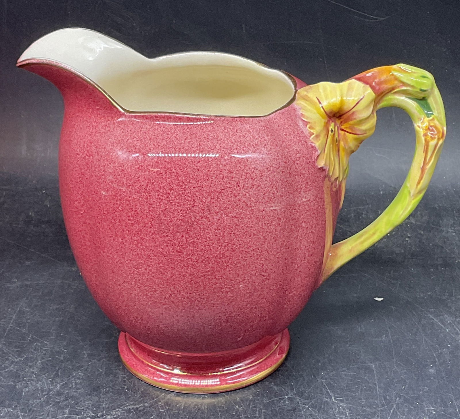 Royal Winton Petunia Milk Jug Creamer, England: Vintage Royal Winton Grimwades ceramic milk jug pitcher. Petunia pattern. Speckled pink with flower motif handle. Signed. Made in England. Measures approx. 6.25 x 4 x 5.25 inches. Wear including crazi
