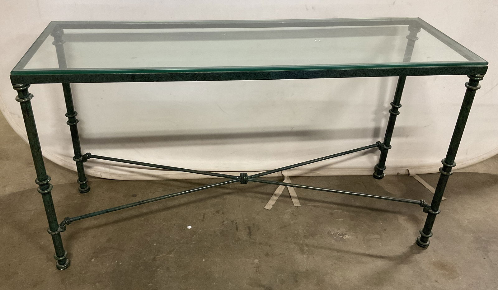 Verdigris Patinated X Frame Glass Console Table: Verdigris patinated metal x frame console table with clear glass top. Top not attached to base. Measures approx. 50 x 17 x 27.5 inches. Some scratching. Green table, verdigris patina table, metal tabl