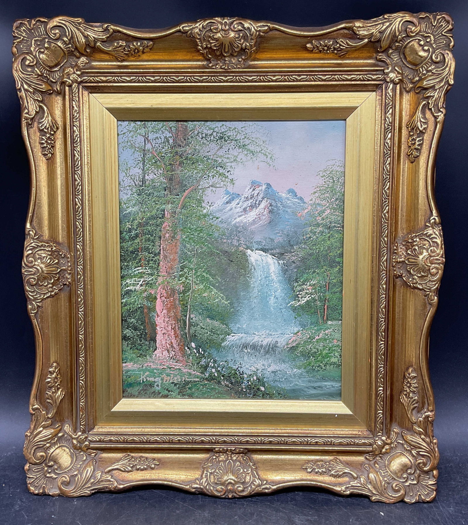 Signed Waterfall Landscape Oil Painting: Framed oil on board painting. Signed at lower left illegibly. Scene landscape with waterfall. Ornate gilt wood frame. Not examined out of frame. Frame measures approx. 13.75 x 15.75 inches. Some marks