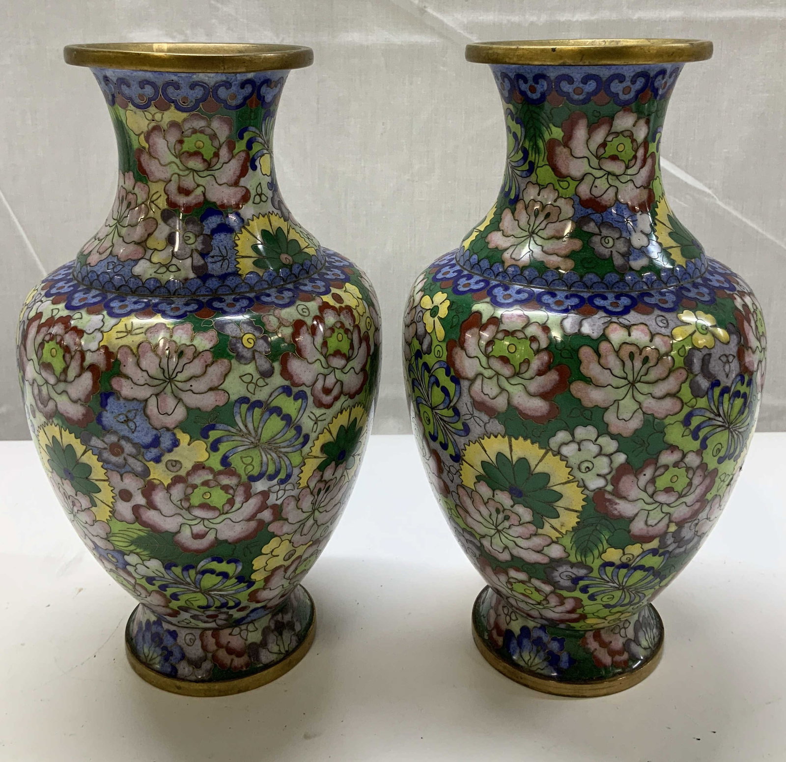 Pair Vtg Asian Cloisonne Enamel Floral Vases: Lot includes, a pair of vintage Asian cloisonne enamel vases featuring vibrant floral motifs. Shades of green, pink, yellow, blue & red. Gilt accents. Surface wear consistent to age, use & exposure. M