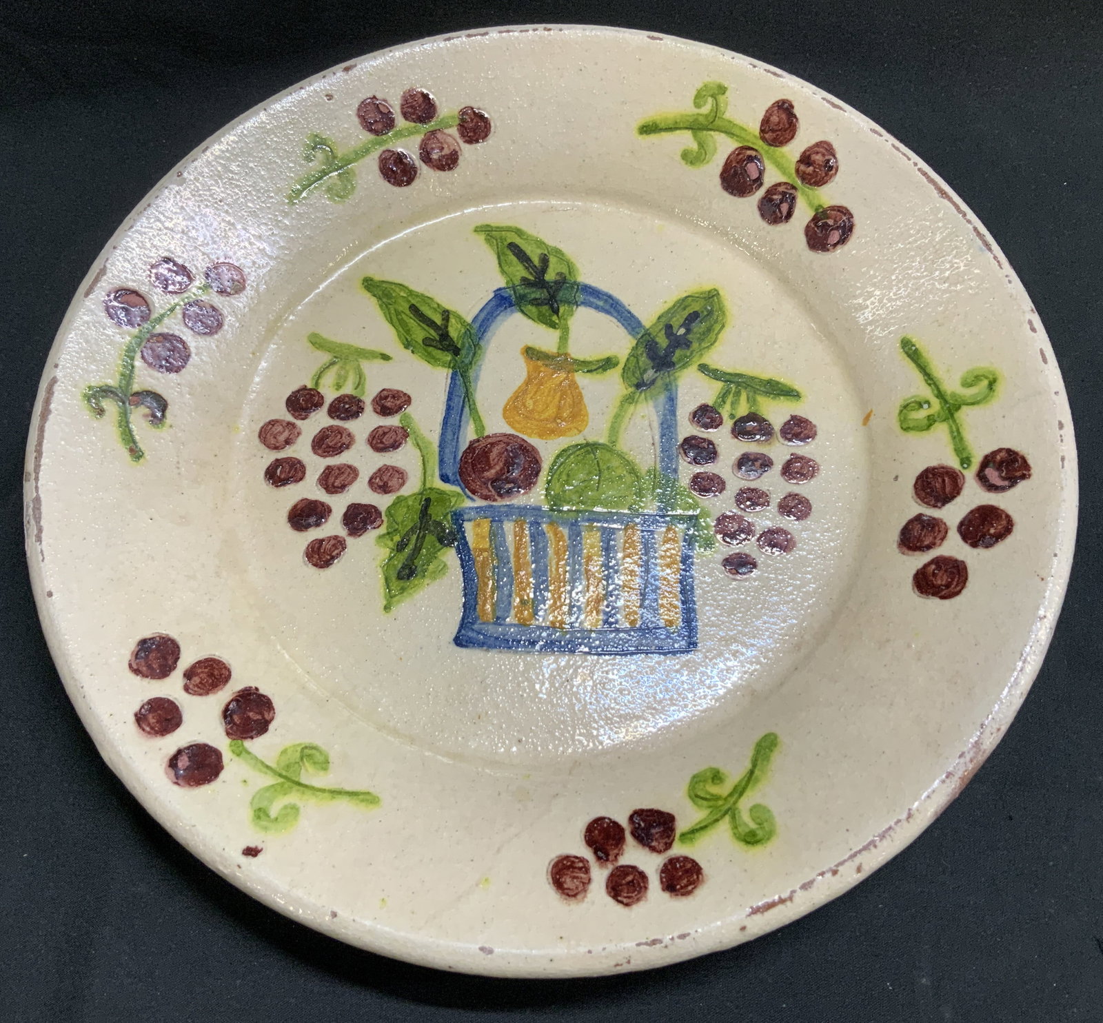 Sgnd Hand Painted Fruit Motif Pottery Plate: Pottery plate features hand painted fruit motifs in center & border. Yellow & blue striped basket with various fruits. Signed & marked on underside. Reads, REDONDA MATELO. Surface wear consistent to a