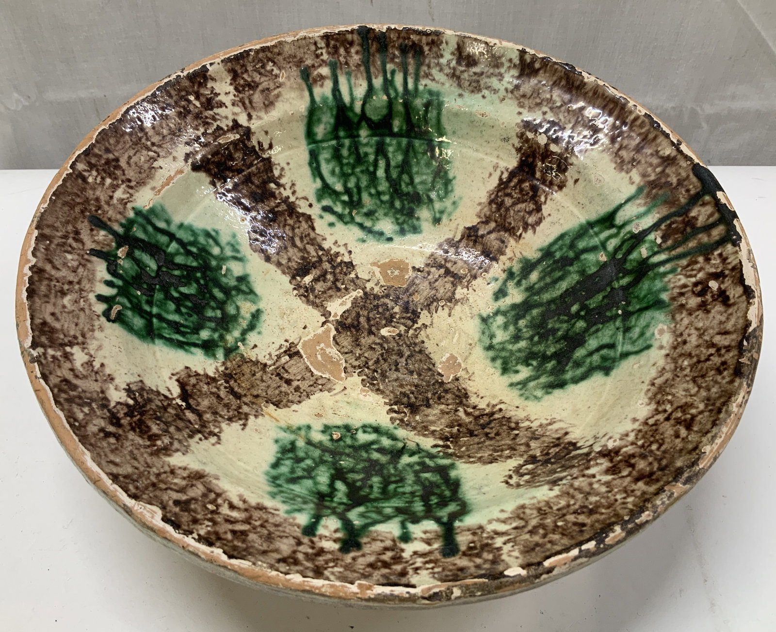 Antique Brown & Green Pottery Bowl: Antique, possible vintage. Pottery bowl features a brown & green glazed finish. Round shape. No visible signature or markings. Surface wear consistent to age, use & exposure. Measurements: length 9.6i