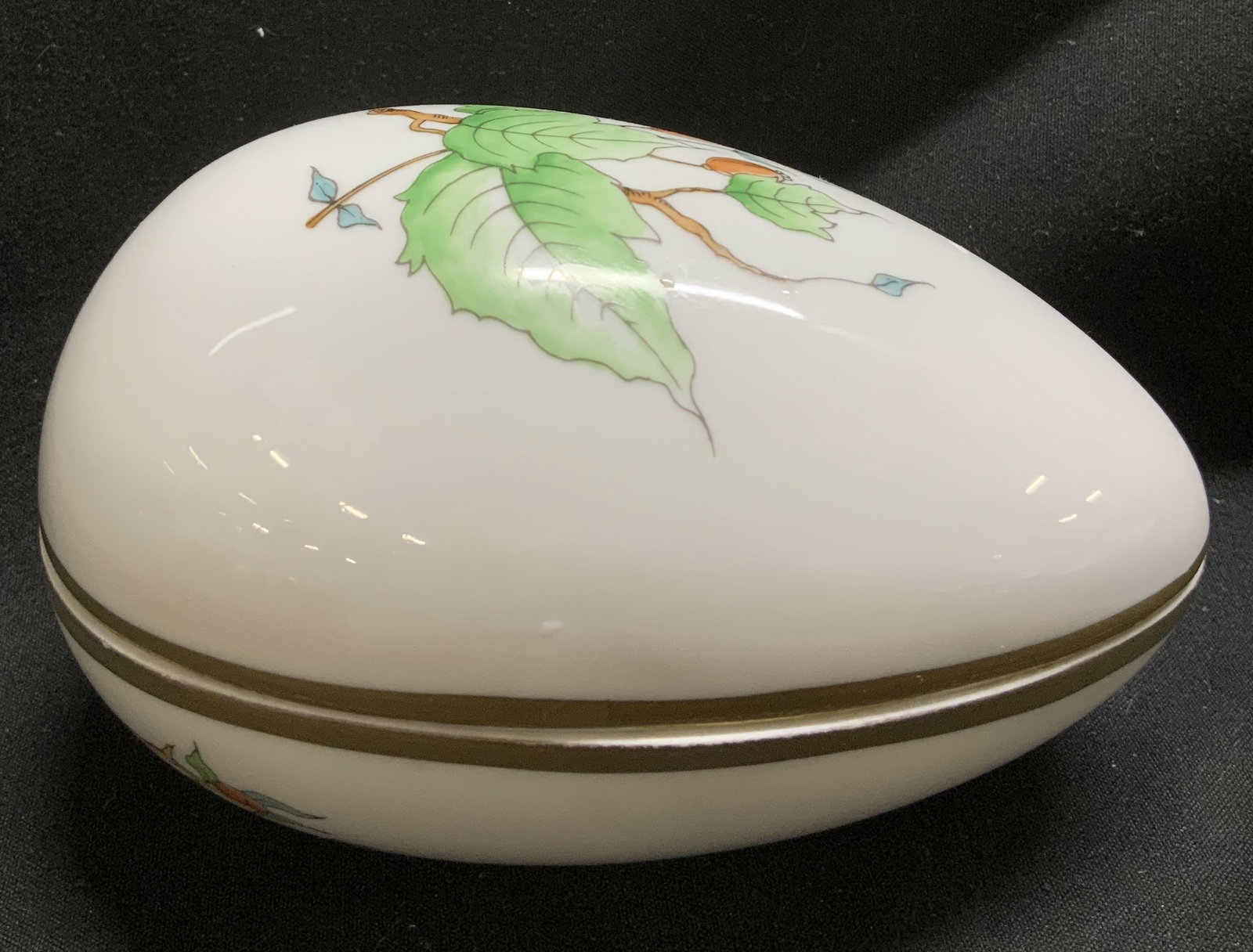 Vtg Herend Leaf Motif Porcelain Trinket Box: Vintage porcelain trinket box features an egg shape & hand decorated leaf motifs. Gilt accents. Signed & marked on underside. Reads, HEREND. Surface wear consistent to age, use & exposure.