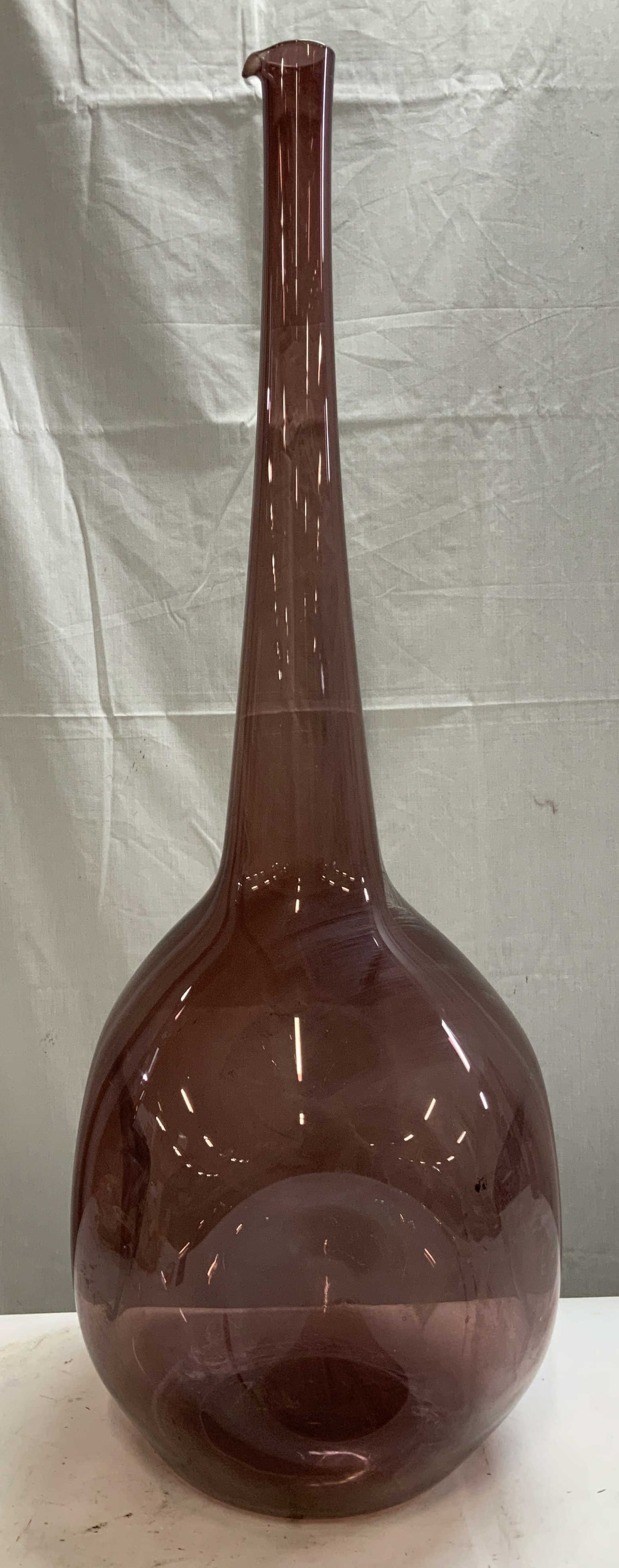 Large Vtg Purple Art Glass Vessel 31.5in.: Large vintage purple art glass vessel features a bulbous base & dimples. Long slender neck. No visible signature or markings. Surface wear consistent to age, use & exposure. Measurements: length 10in