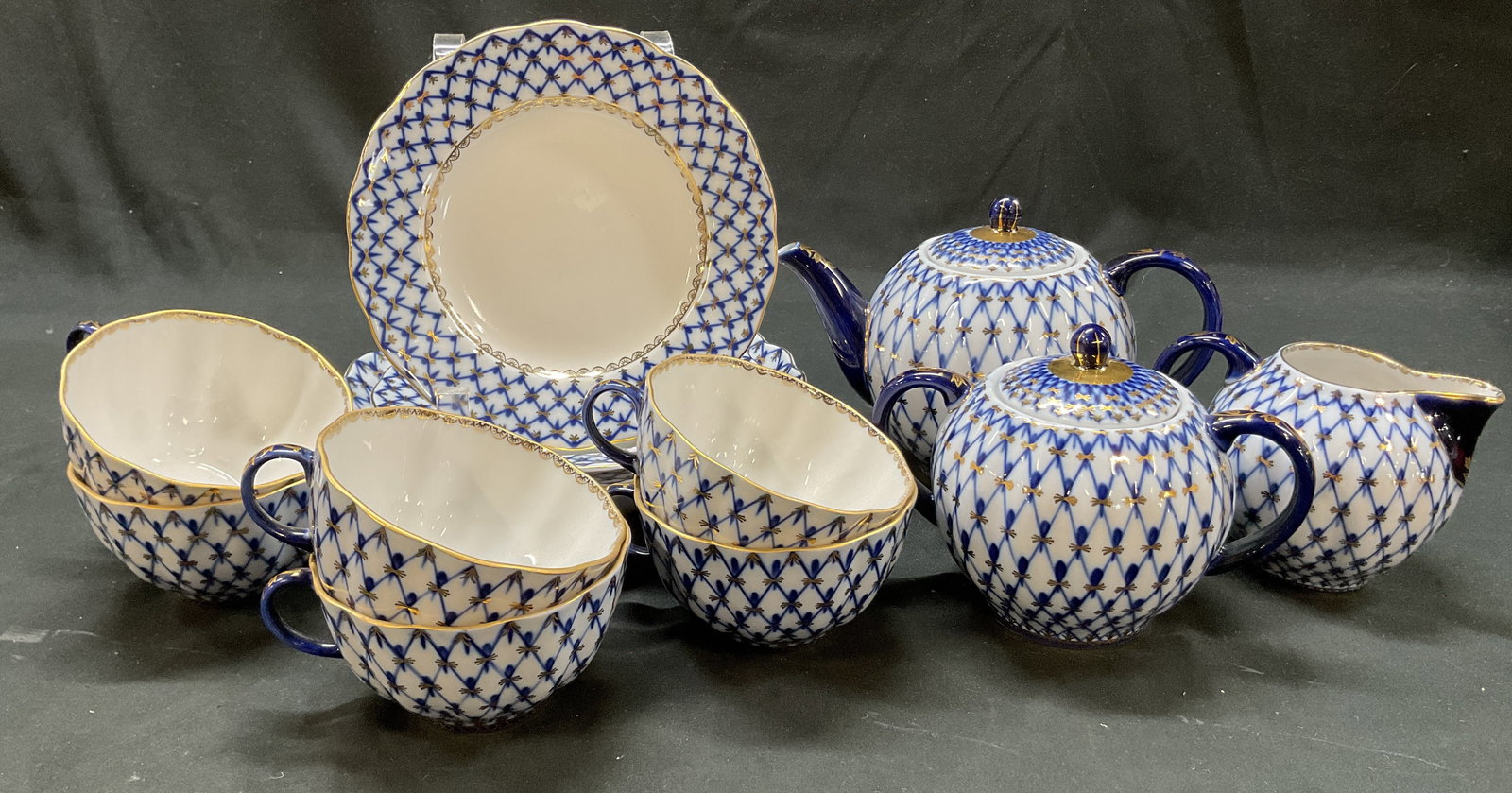 Set 13 SGND Lomonosov Cobalt Blue Tableware Russia: 13 piece Lomonosov cobalt blue porcelain tableware set. Marked on underside, reads Hand Decorated 1744 St. Petersburg Russia. Signed with Lomonosov stamp. Includes 1 cake plate, 3 dessert plates, 1 cr