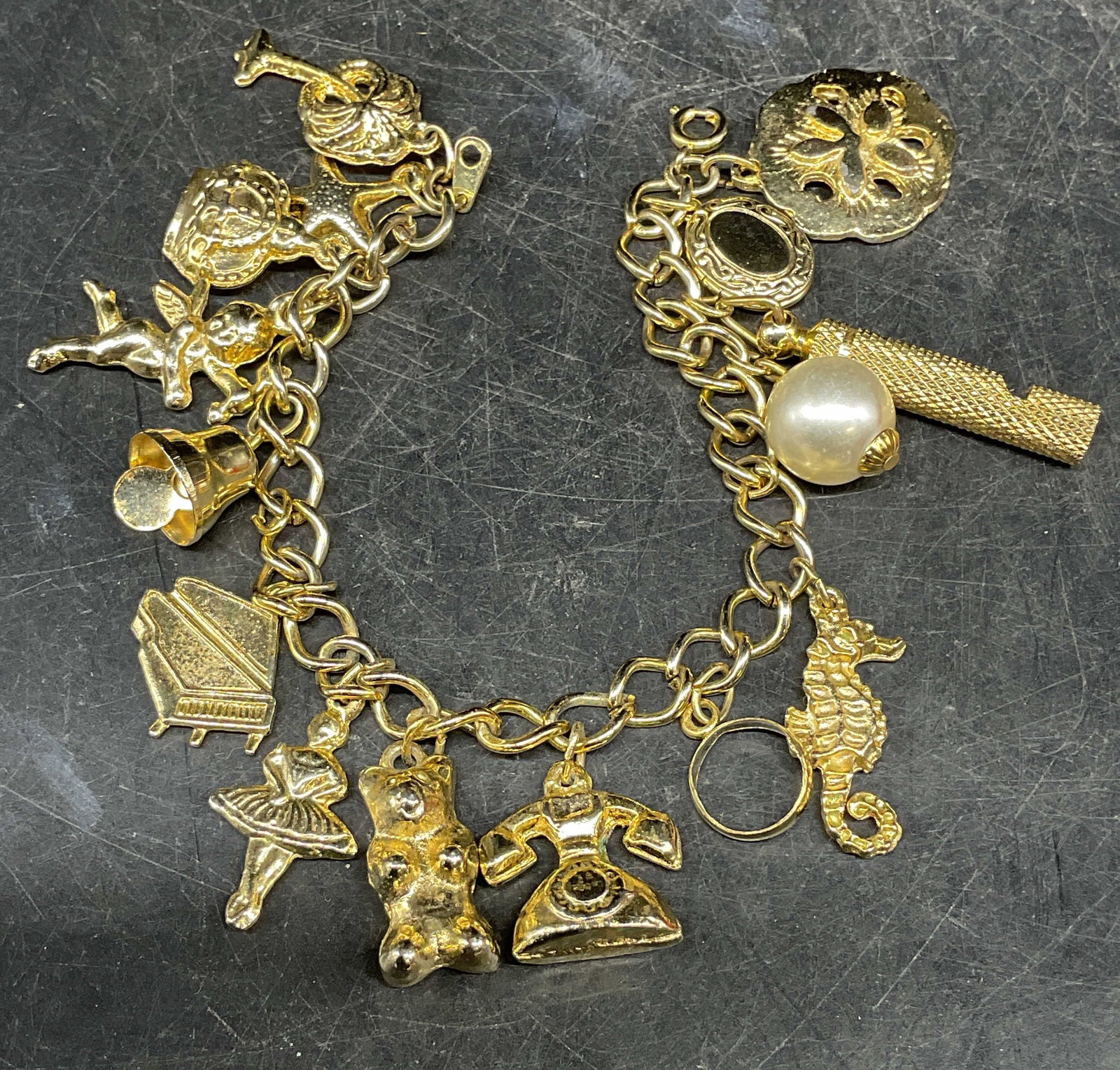 Vintage Gold Tone Charm Bracelet: Vintage gold tone charm bracelet. Ballet, teddy bear, crown, flower, seahorse, and more charms. Measures approx. 6.75 inches long. Bracelet has weight. Some scratching. Jewelry, estate jewelry, costum