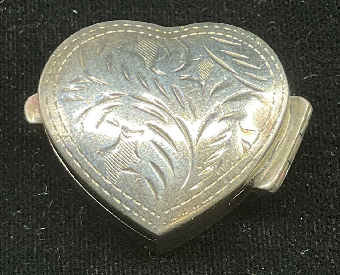Vtg Sterling Silver Heart Trinket Pill Box: Vintage sterling silver heart shaped trinket or pill box with etched botanical design. Marked sterling. Measures approx. 1 x 1 x 3/8 inches. Total weight 6.9 grams. Some patina and scratching.