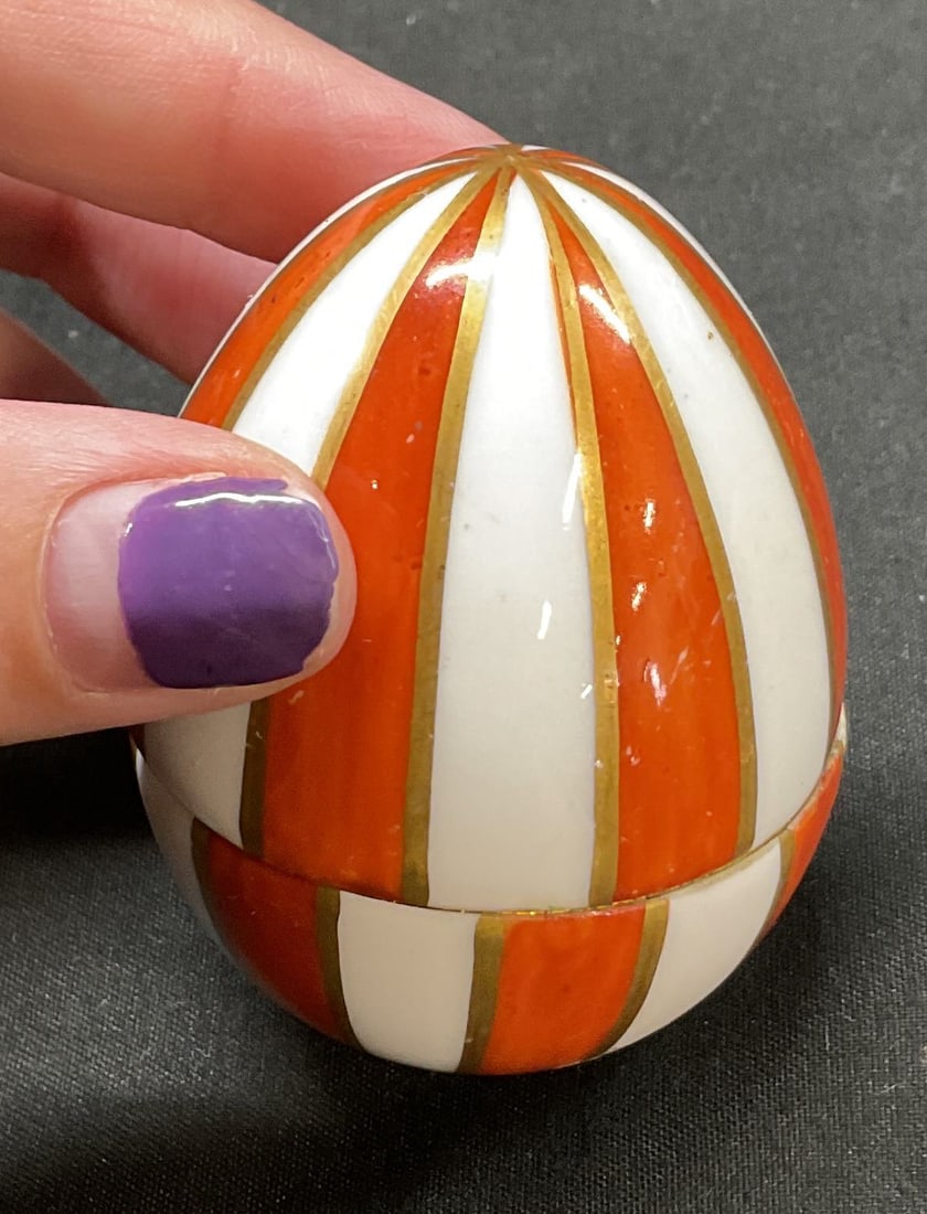 Limoges Porcelain Egg Shaped Trinket Box France: Limoges porcelain egg shaped lidded trinket box. Marked on surface, reads Chamart France Limoges Peint Main. Egg shaped box. Hand painted striped pattern in orange with gilt accents. Gilt rim. Measure