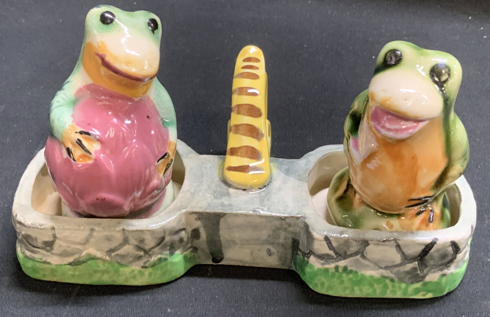 Vtg Ceramic Frog Salt & Pepper Shakers JAPAN: Vintage ceramic salt & pepper shaker set featuring two frogs sitting in a basket-like tray. Hand painted details with glossy finish. Signed & marked on underside. Reads, MADE IN JAPAN. Surface wear co