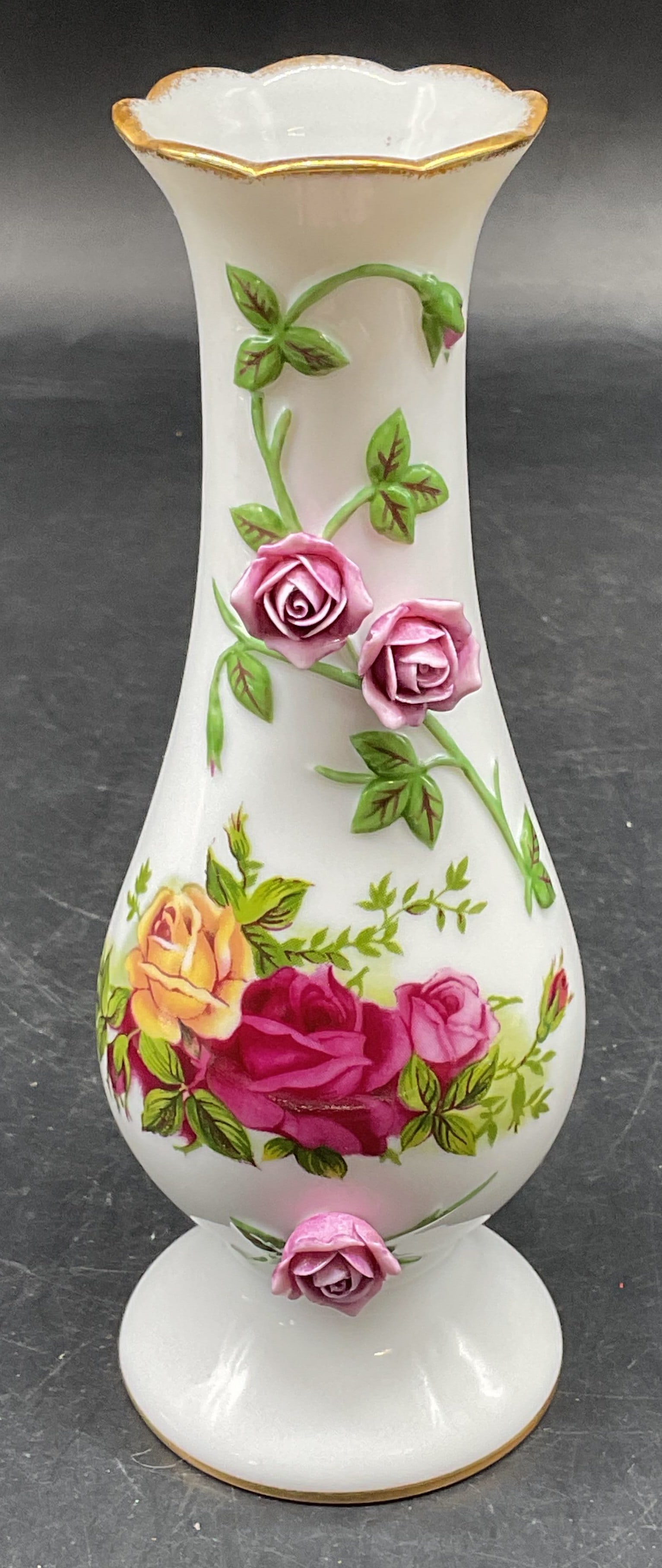 Royal Albert Old Country Roses China Vase: Signed Royal Albert Old Country Roses fine china sculpted Bud vase. Floral designs. Curved with footed base and scalloped rim. Copyright date 1962. Measures approx. 2.5 x 6.5 inches. Some scratching.