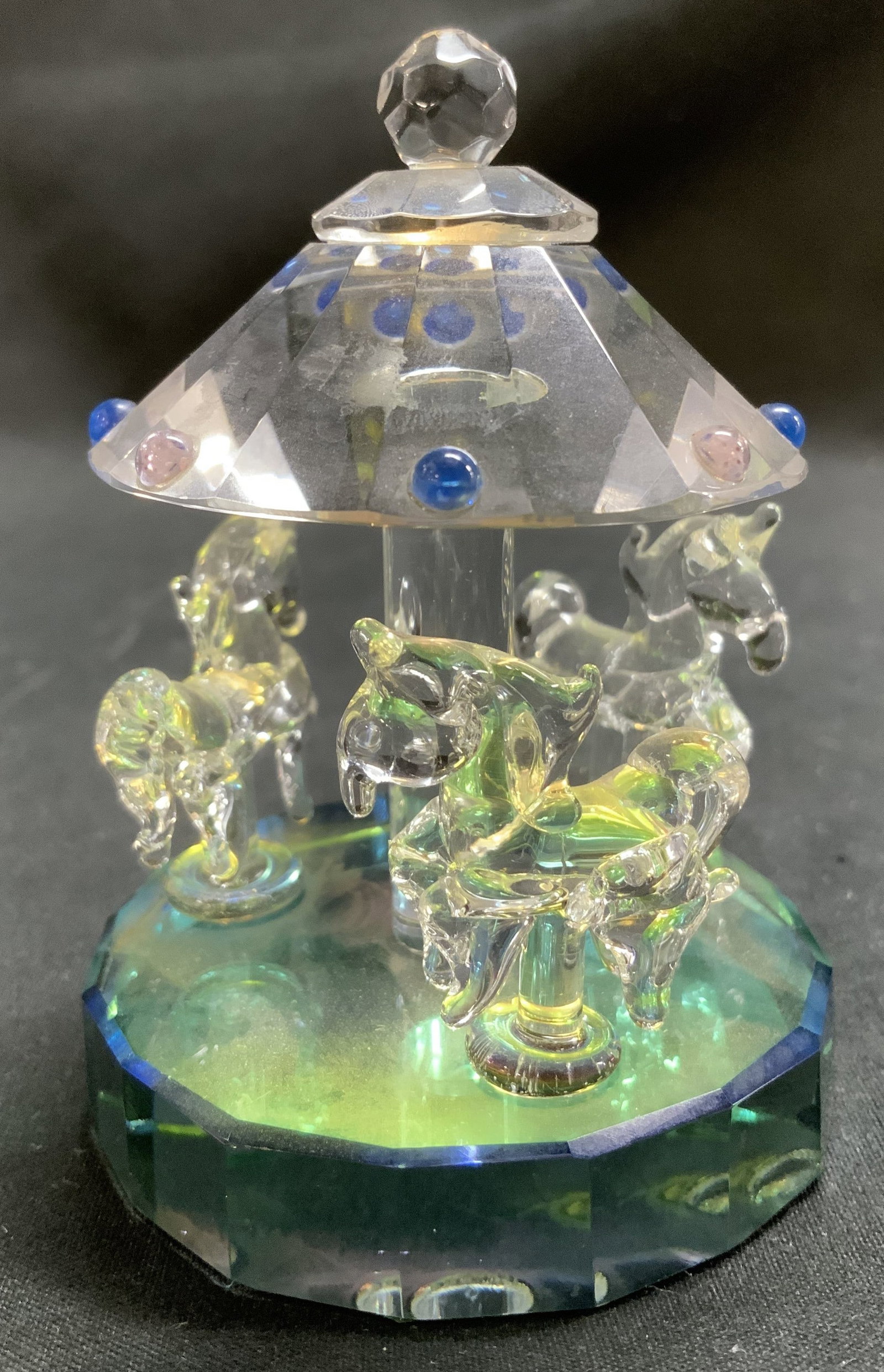 Vtg Merry Go Round Carousel Crystal Fig: Vintage Merry Go Round Carousel decorative crystal figurine featuring horses under a faceted roof. Jeweled accents on roof. Green & clear toned. No visible signature or markings. Surface wear consiste