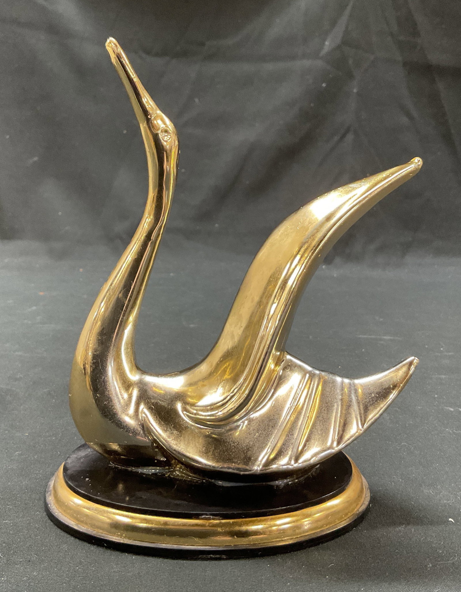 Vintage Brass Toned Swan Figure Italy: Vintage brass toned swan figure. Marked made in Italy. Oval shaped base. Detailed features and textures. Ribbed surface. Measures approx 3 x 4 x 6 inches. Surface wear consistent with exposure. Swan f