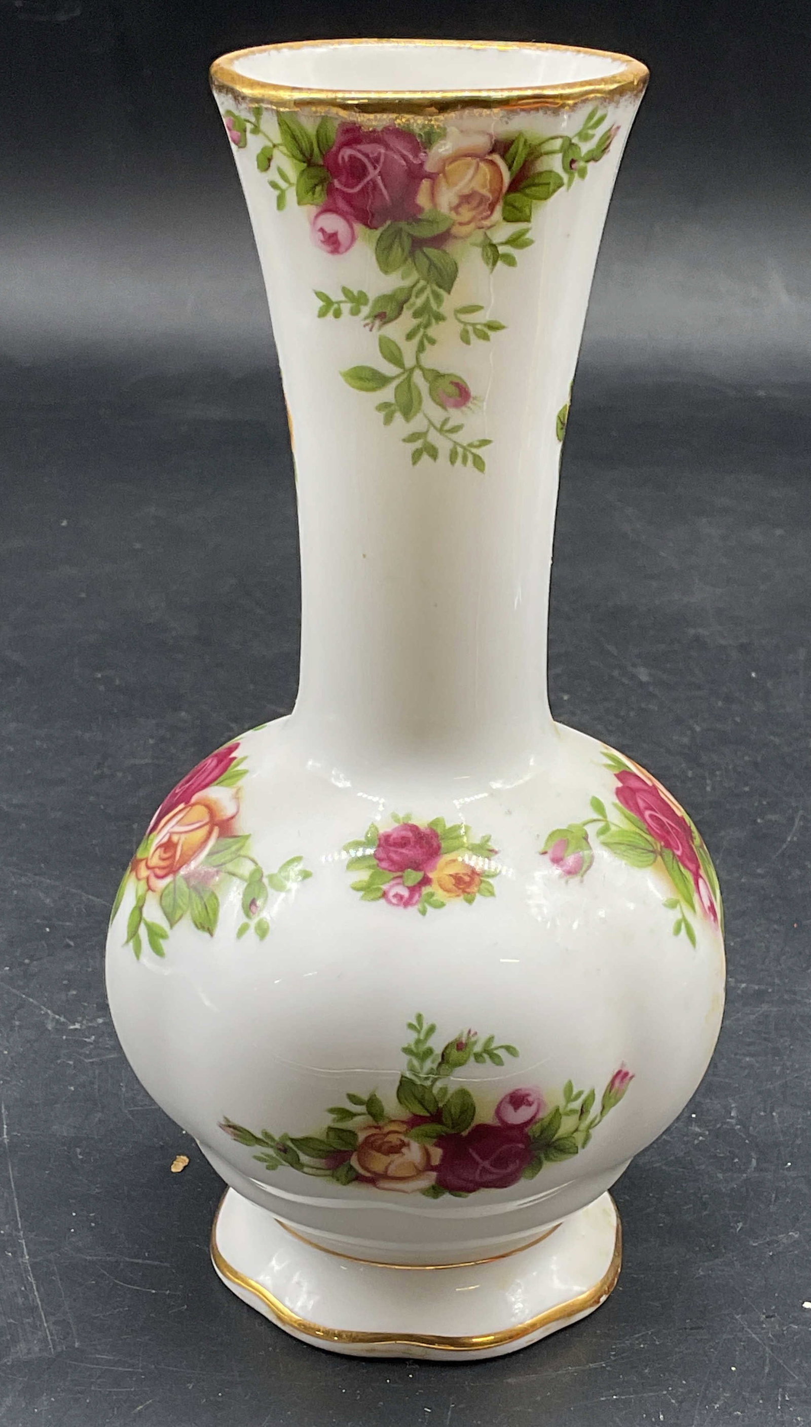 Royal Albert Old Country Roses China Vase: Signed Royal Albert Old Country Roses bone china bud vase. Floral designs. Curved shale with footed base and fluted rim. Copyright date 1962. Measures approx. 2.75 x 6 inches. Some scratching. Royal A