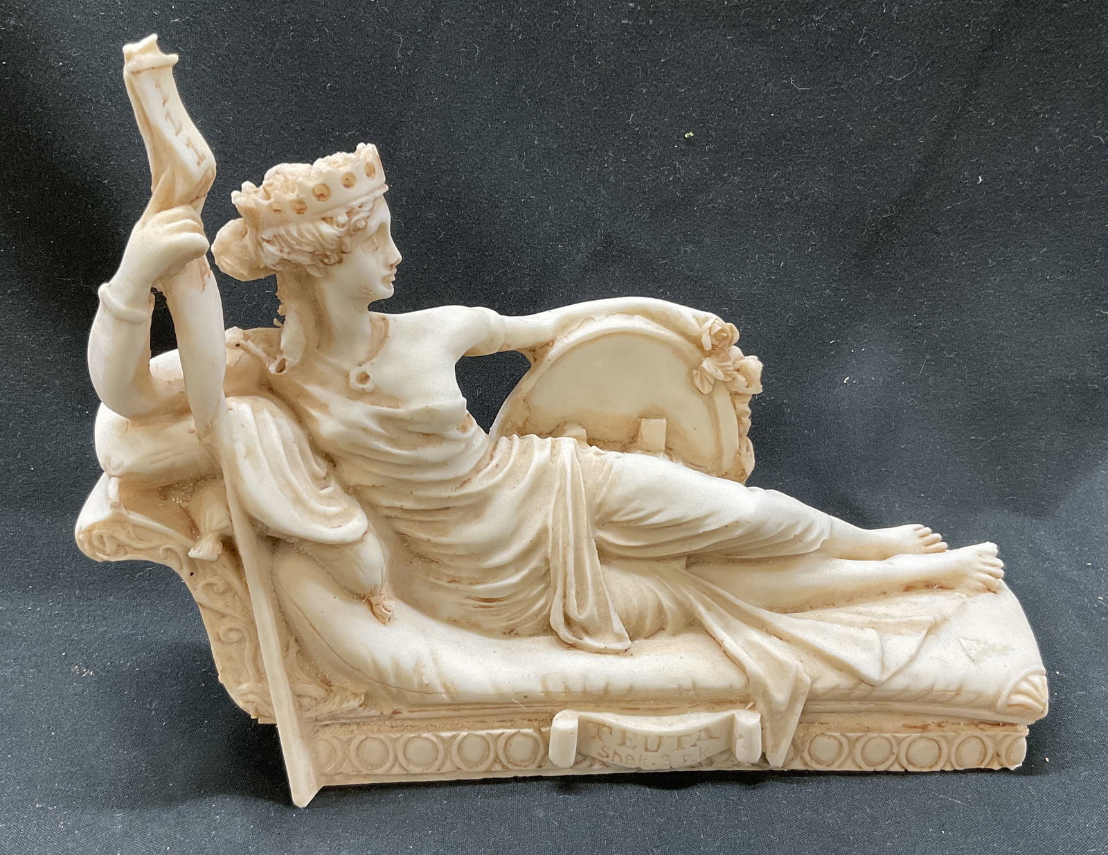 Illyrian Queen Teuta Figurine: Illyrian Queen Teuta Figurine. Queen Teuta holding a shield and banner. Neoclassical Style. Made of Resin. Some chipping consistent with exposure. Measures app 6in H x 2in W. Illyrian, Illyrian Queen,