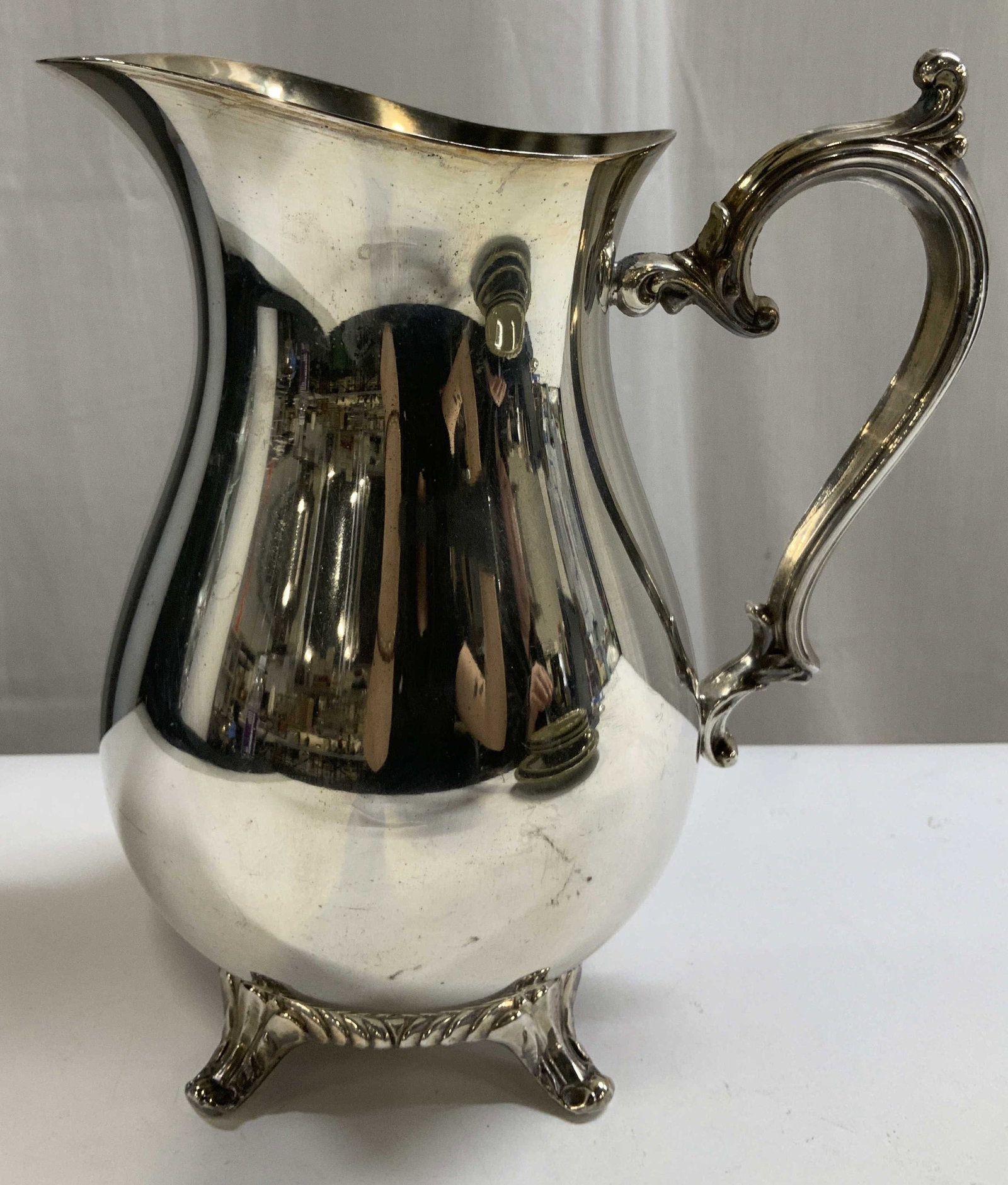 Vtg WM Rogers Silver Plated Pitcher: Vintage WM Rogers silver plated pitcher features an ornate handle & feet. Signed & marked on underside. Reads, WM ROGERS. Surface wear consistent to age, use & exposure. Measurements: length to handle