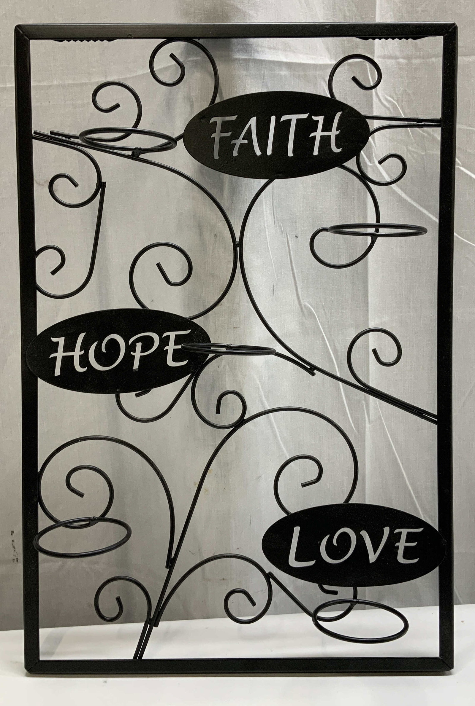 Faith, Hope, Love Metal Wall Scone: Black metal frame with candle holders & cut out lettering reading, Faith, Hope & Love. No visible signature or markings. Surface wear consistent to age, use & exposure. Measurements: height 18in x wid