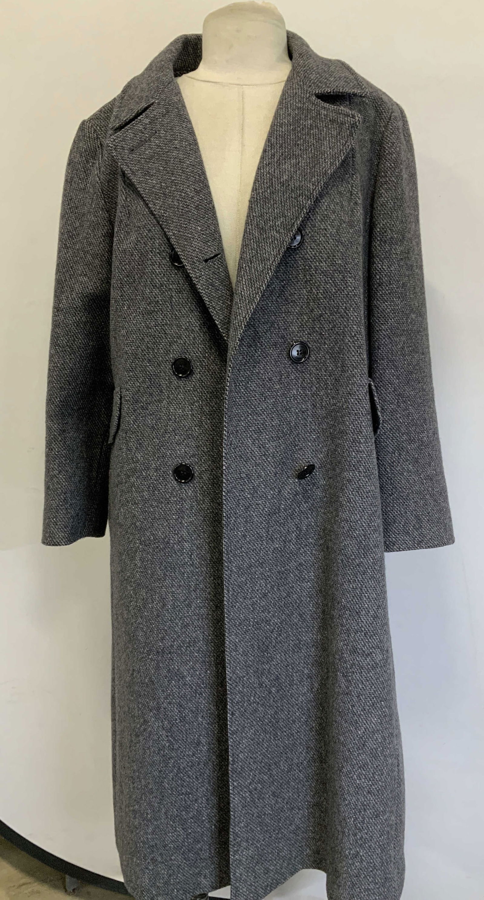 Designed By Anlette Grey Button Overcoat USA: Long overcoat is grey toned & features a textured tweed style pattern. Double-breasted front closure with black buttons. Pockets on sides. Piece has weight appears to be possible wool. Signed &