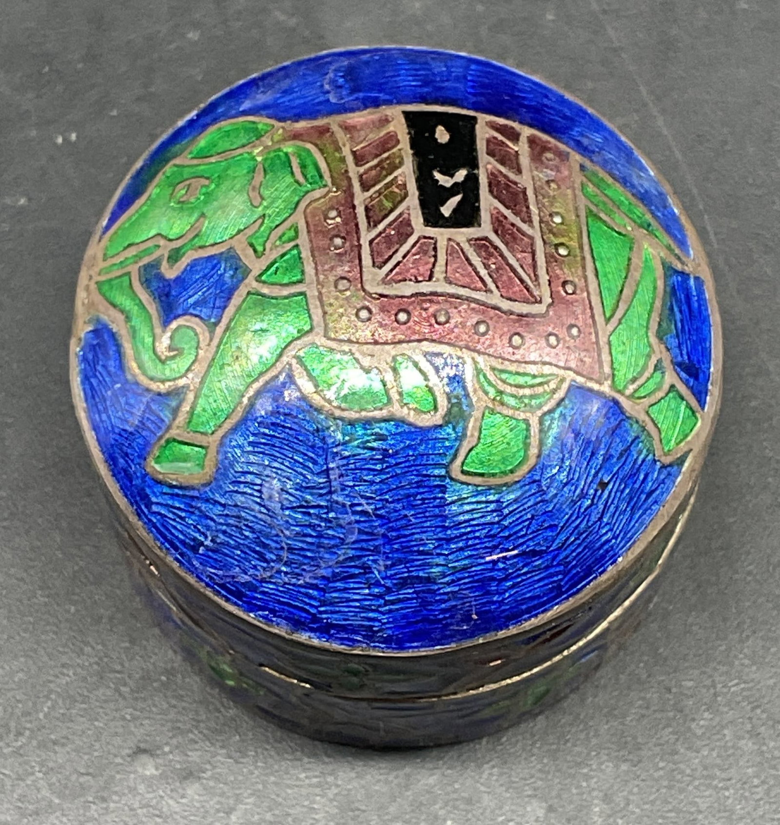 Sterling Silver Guilloche Elephant Pill Box India: Sterling silver guilloche enameled pill box with elephant motif. Marked sterling. Total weight 12.7 grams. Measures approx. 1 x 1 inches. Made in India. Some scratching. Sterling silver pill box, elep